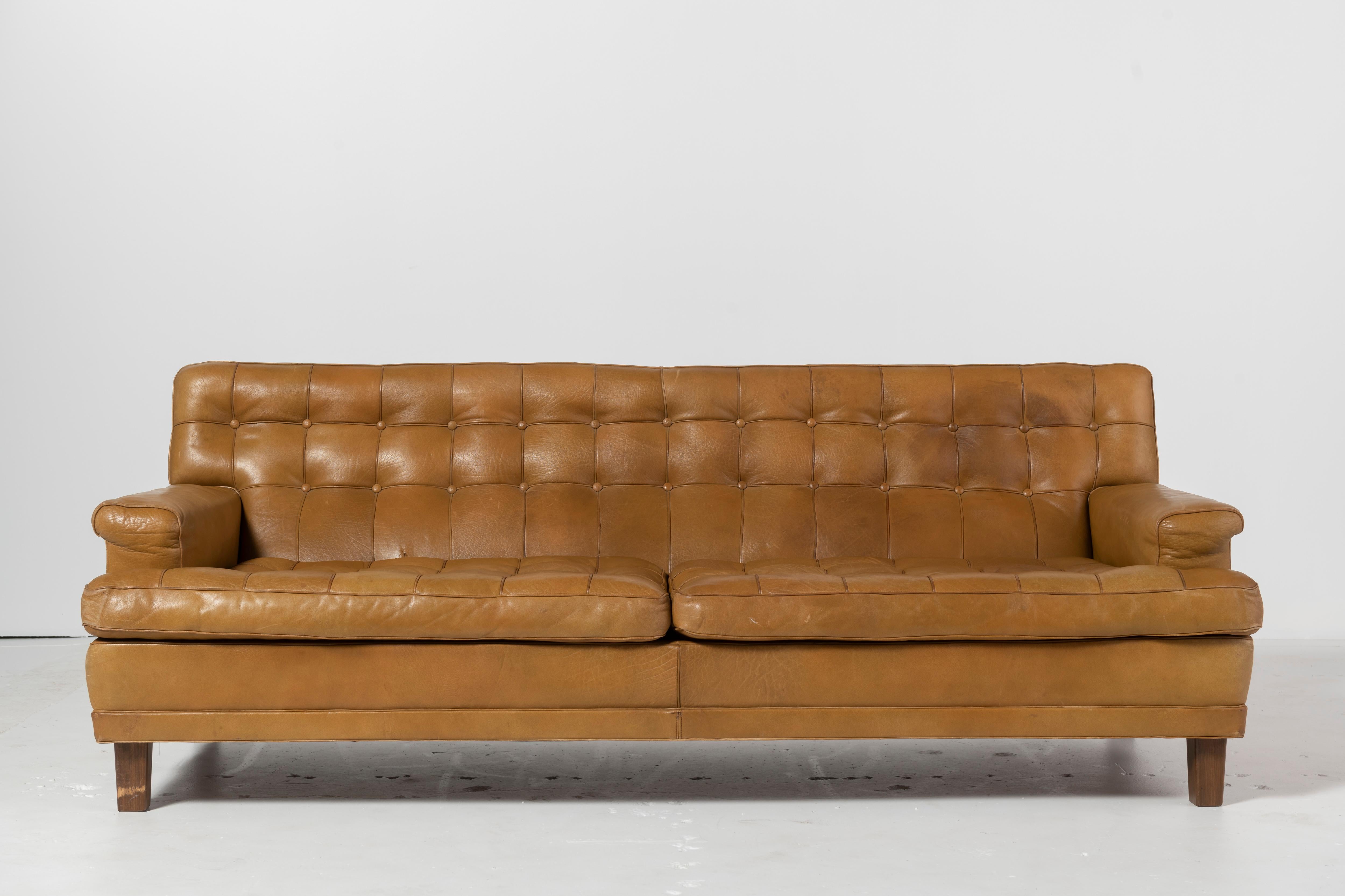 Classic Arne Norell sofa with original buffalo leather in cognac with walnut legs. Good condition and patina. Label intact.