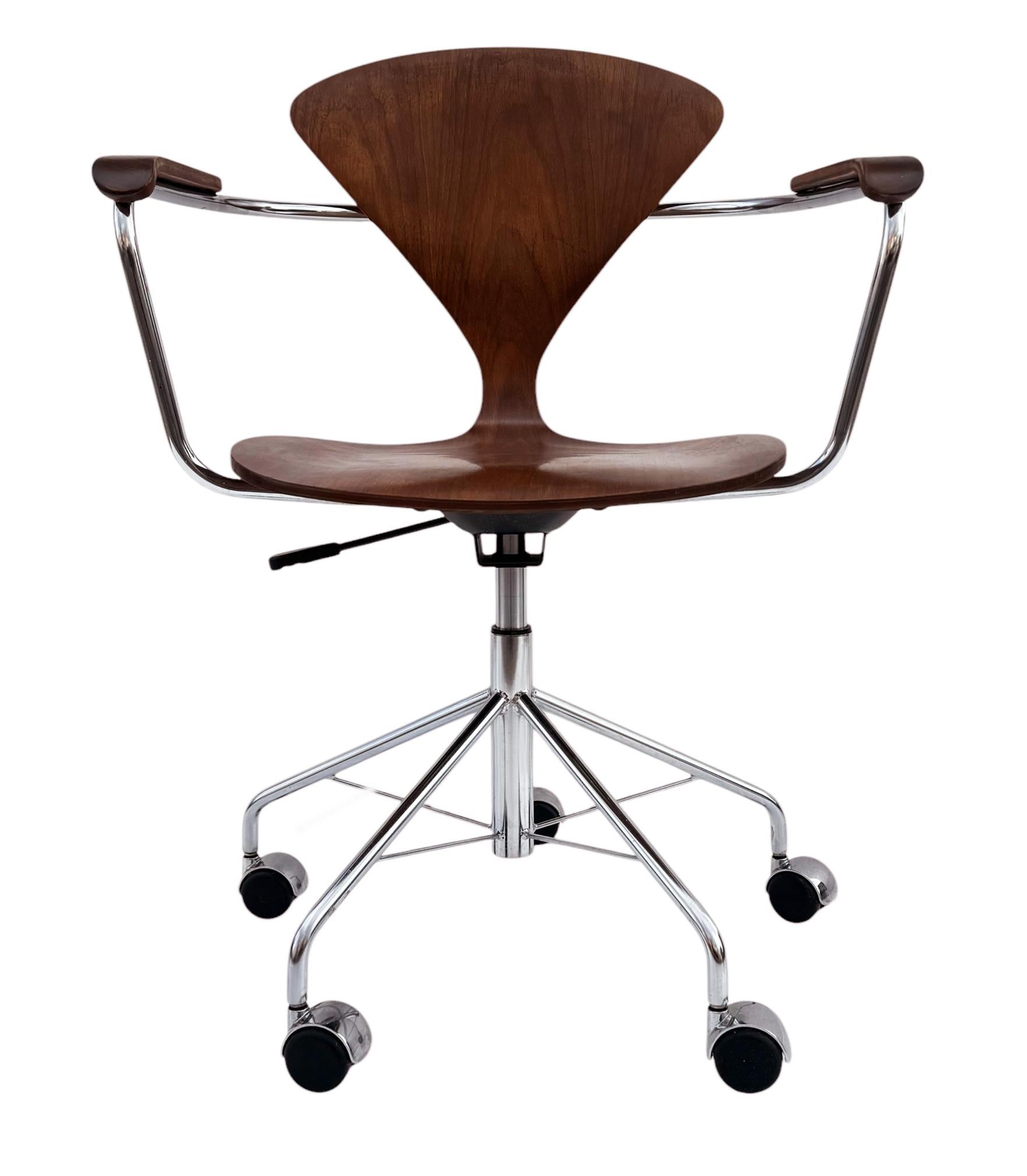 A super clean original armchair task / office chair designed by Norman Cherner for Plycraft. It features a molded walnut seat, height adjustability, swivels with a chrome base on casters. Manufacturer label.