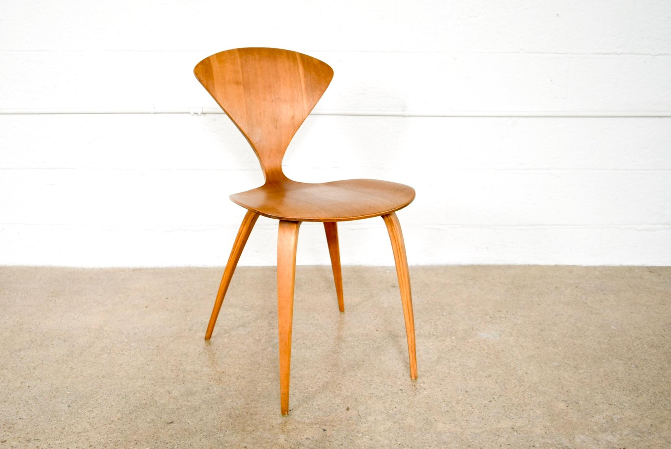 This vintage Mid-Century Modern molded plywood side chair was designed by Norman Cherner for Plycraft in 1958. The iconic sculptural design features elegant curves and a sleek Danish-inspired profile. The chair is exquisitely crafted from molded
