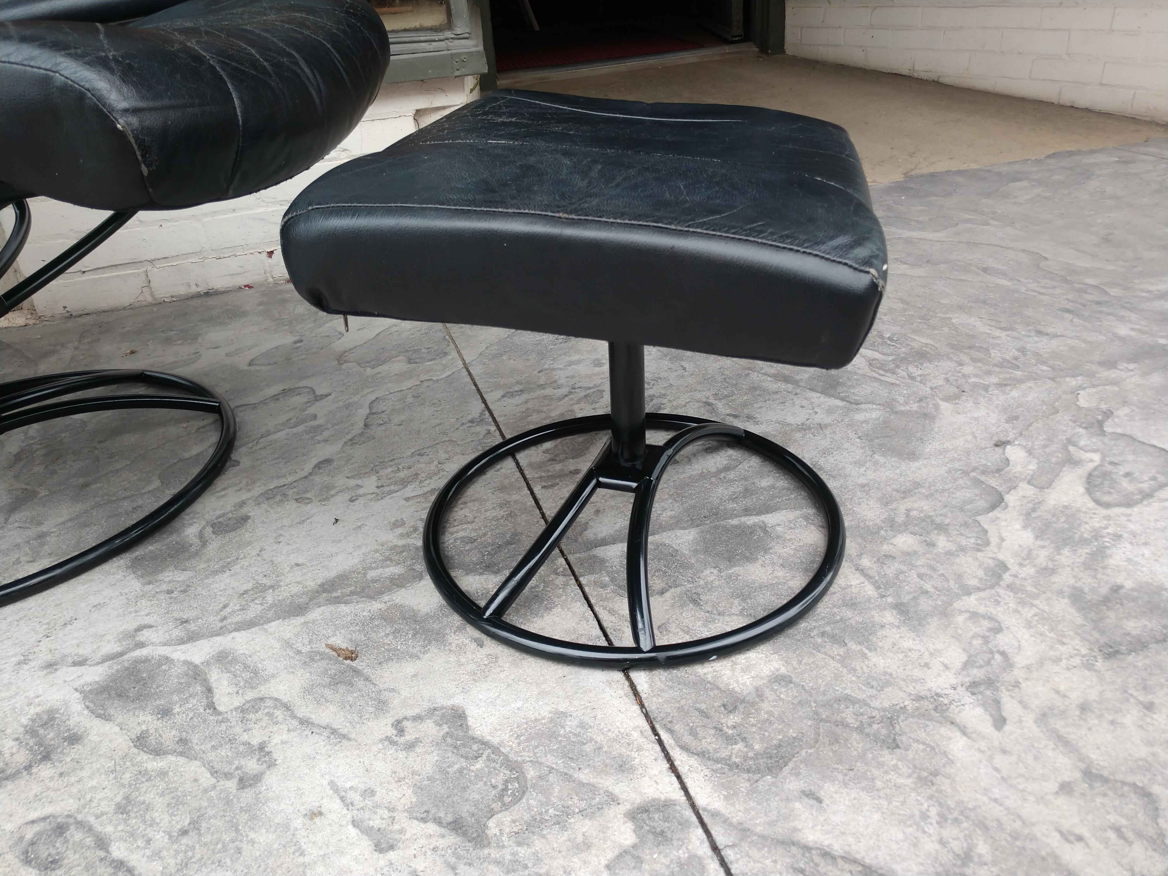 Vintage Ekornes stressless black leather fully adjustable lounge chair with swivelling black leather ottoman. Some minor wear to the leather, no cracks or splits, tears or other damage. Works like a charm. The most comfortable chair to sit in. When