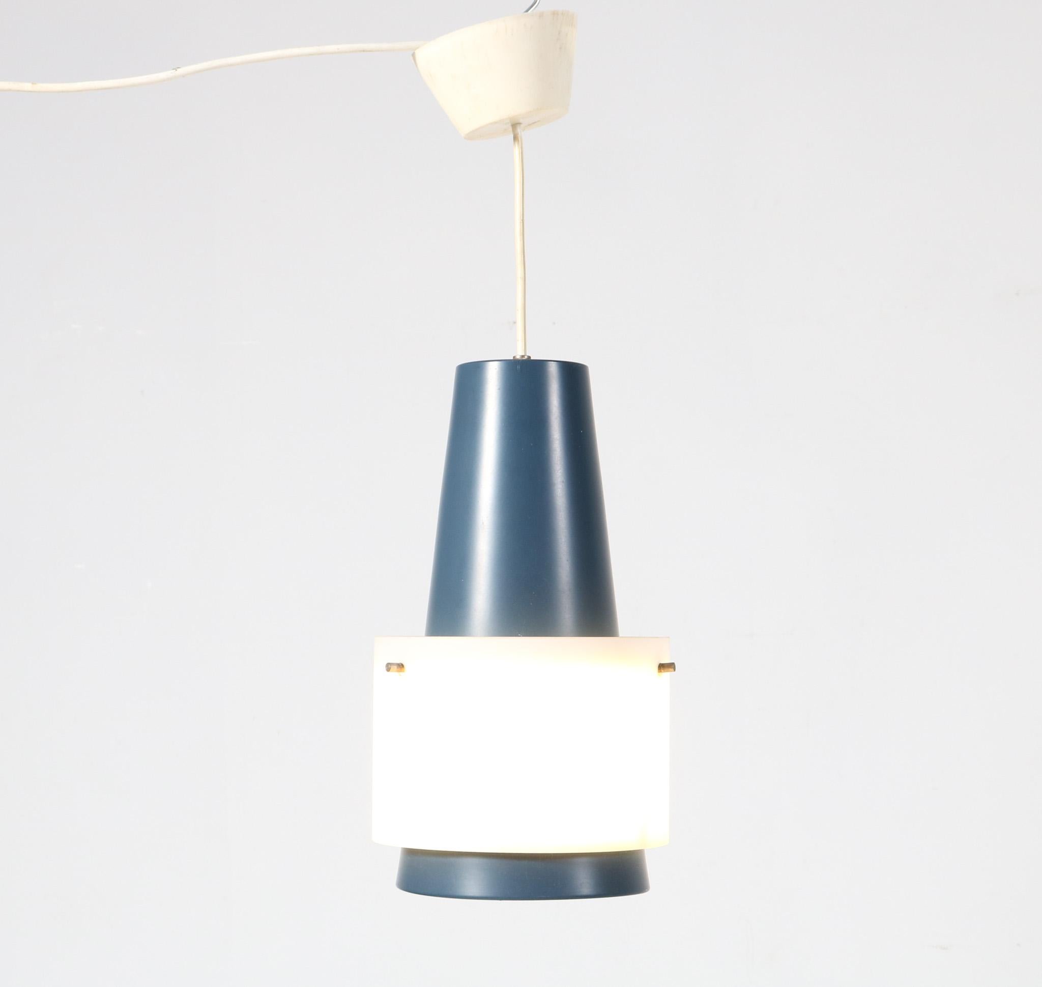 Stunning and rare Mid-Century Modern pendant lamp.
Design by Louis Kalff for Philips.
Striking Dutch design from the 1950s.
Original blue lacquered metal frame with original milk glass shade.
In very good original condition with minor wear