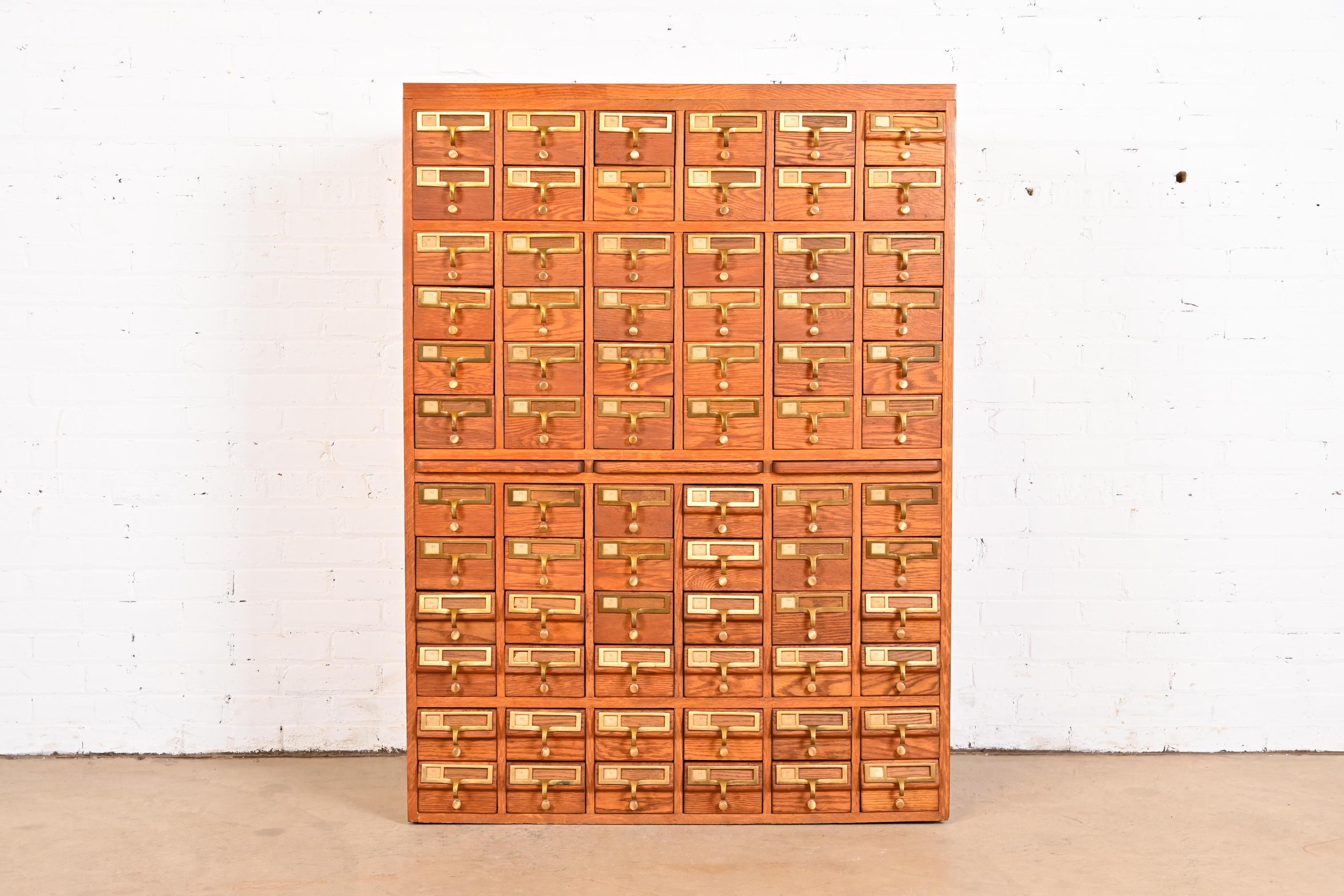 A rare and exceptional Mid-Century Modern 72-Drawer library card catalog cabinet

USA, Circa 1950s

Oak, with brass hardware, metal drawer interiors, and three pull-out writing tablets.

Measures: 39.25