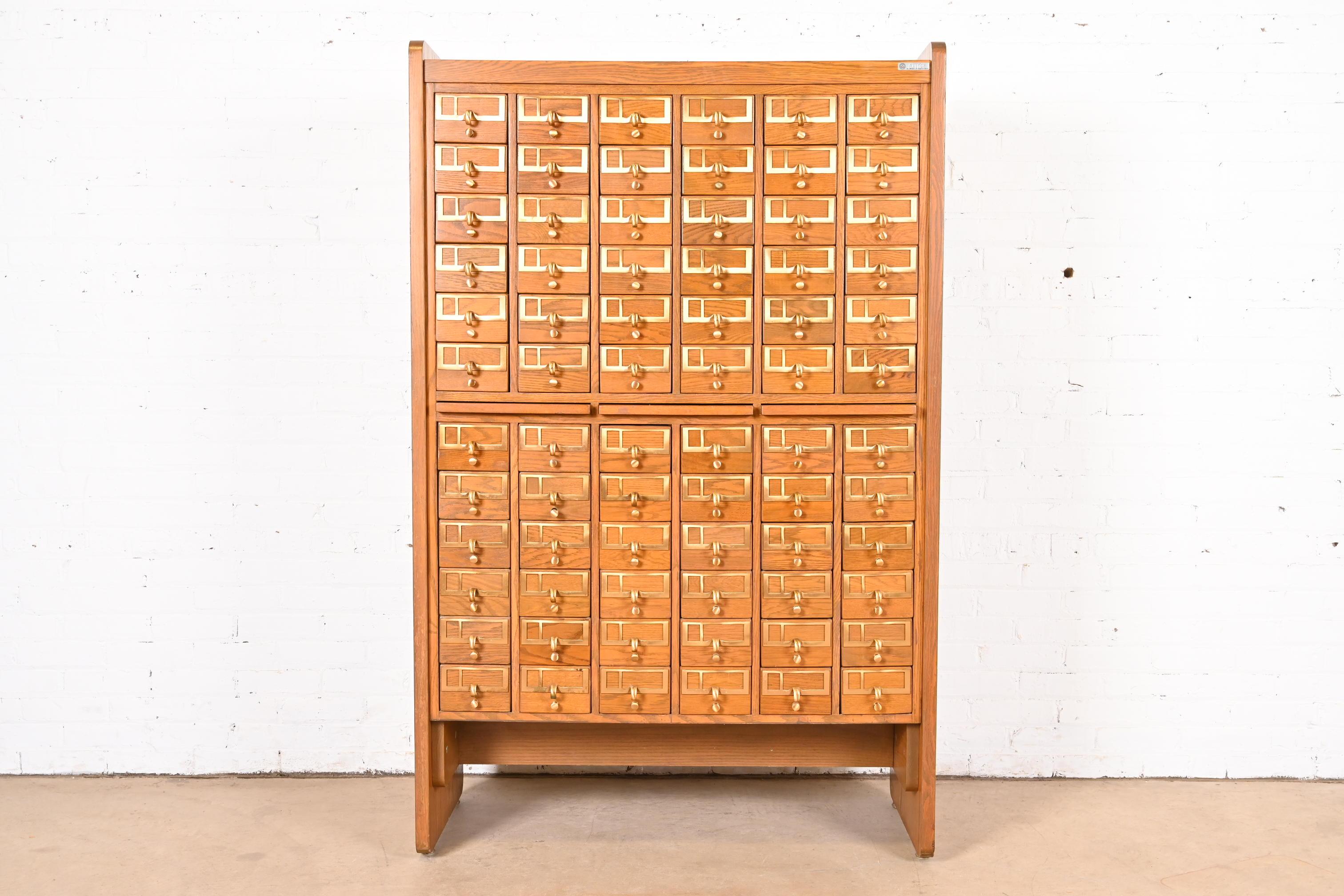 A rare and exceptional Mid-Century Modern 72-Drawer library card catalog cabinet

Procured from University of Texas at Austin (label present)

USA, Circa 1960s

Oak, with brass hardware, plastic drawer interiors, and three solid oak pull-out writing