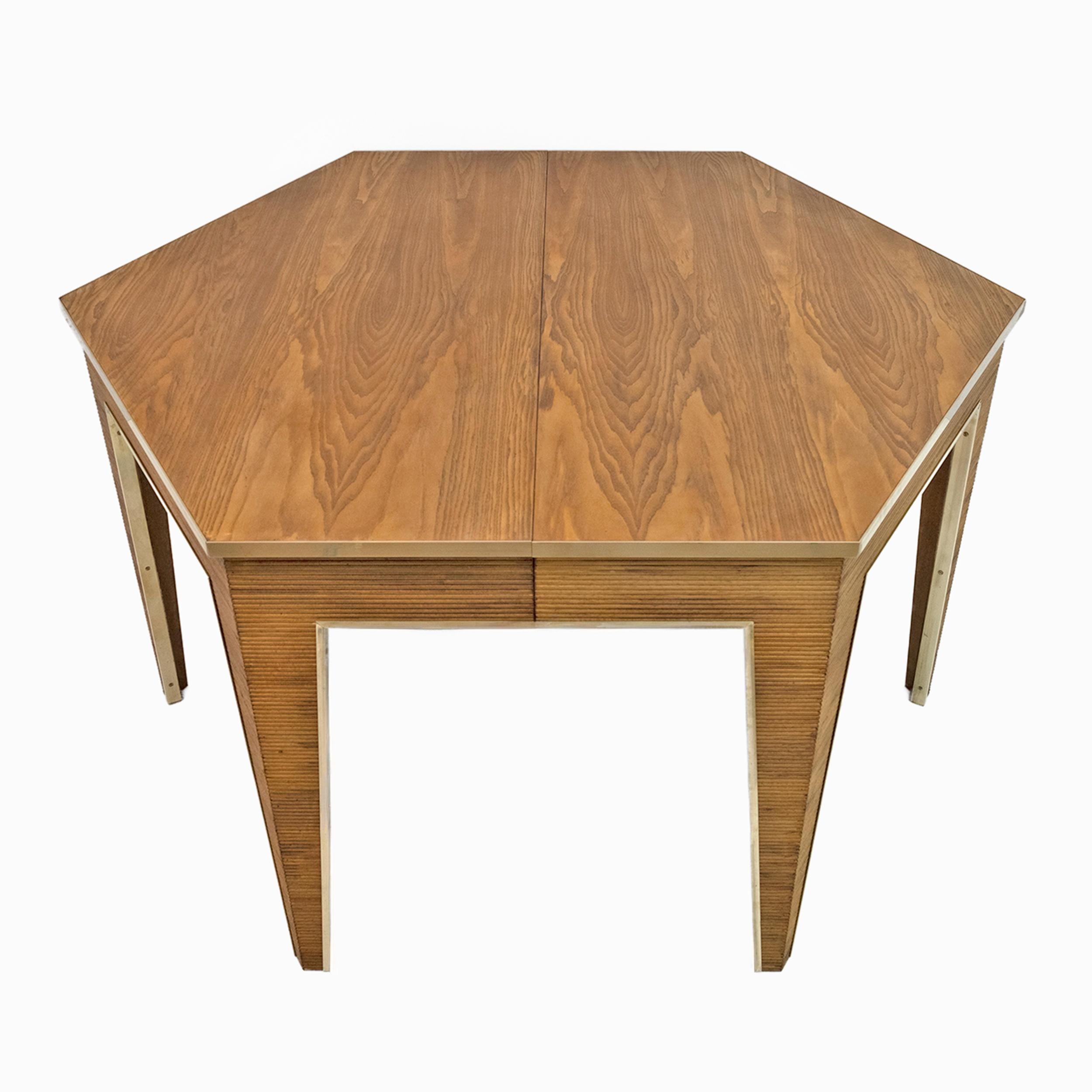 Mesa hexagonal de los años 70, En roble y latón, elaboración a palillo en la base, la mesa es extensible, tiene cuatro extensiones y alcanza una longitud de 307 cm. La mesa ha sido restaurada y el latón pulido.