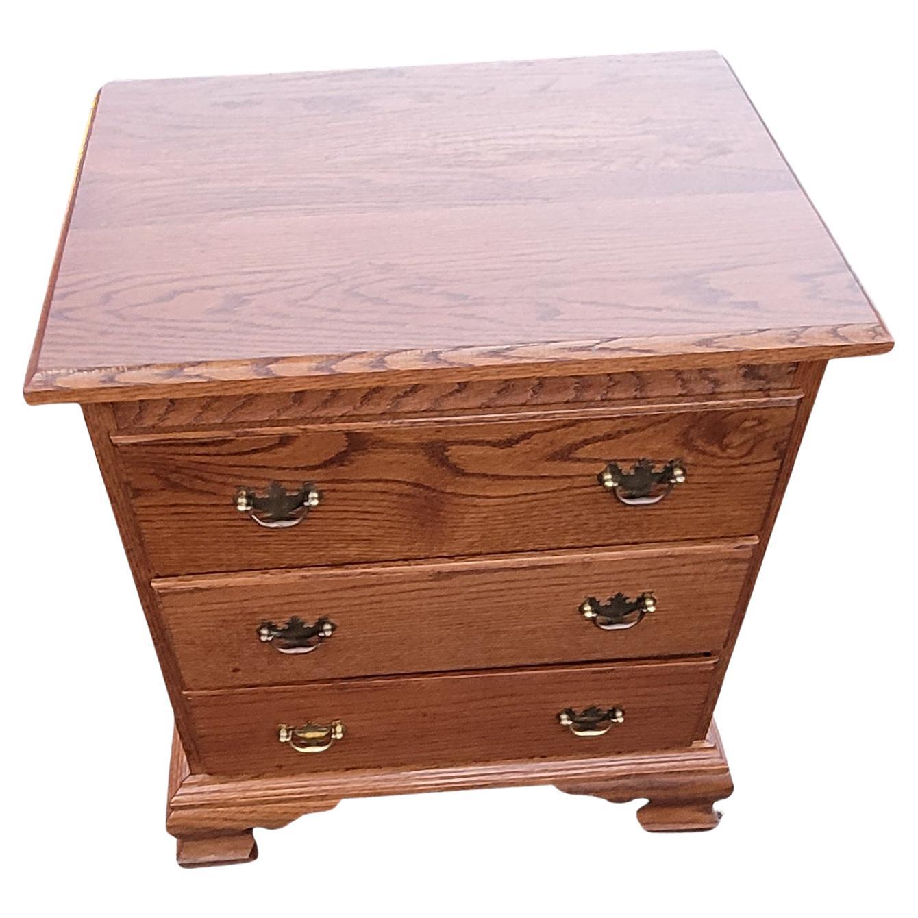 Mid-century Pennsylvania house oak bedside chest of drawers nightstand featuring three drawers with dovetailed construction in great working condition. Measures 21.75