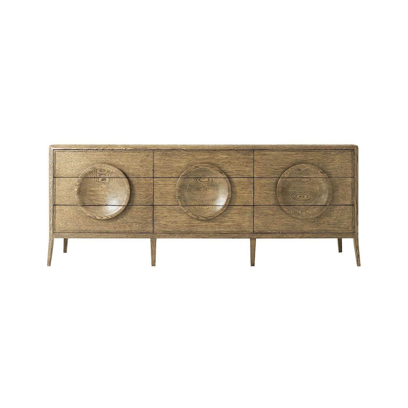 A Mid-Century Modern style solid oak and quarter oak veneered nine-drawer dresser. With dish form, decorative drawer pulls and splayed legs. The self-closing drawers are lined on the bottoms with felt.
