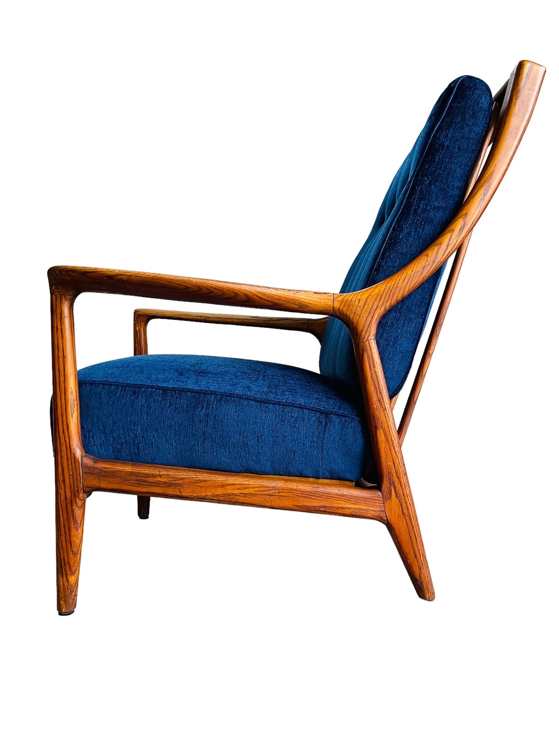 Stunning Mid Century Modern Oak Lounge chair by Jack Van Der Molen. This chair has new upholstery in a midnight blue fabric on beautifully sculpted Oak frame. The chairs seat slides forward for a more relaxed lounging experience. The chair is in