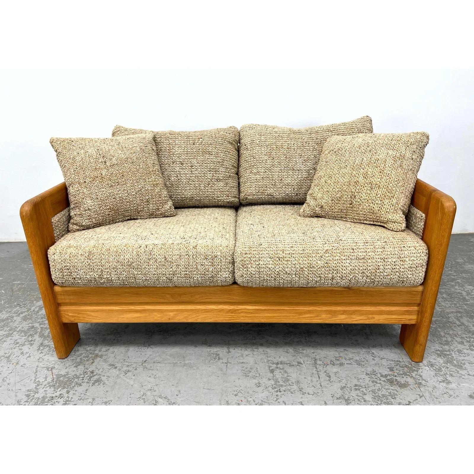 Este loveseat moderno de mediados de siglo tiene una estructura de roble macizo de líneas limpias y construcción robusta.  De tamaño compacto, funciona bien en apartamentos, rincones de lectura o salas de estar.


