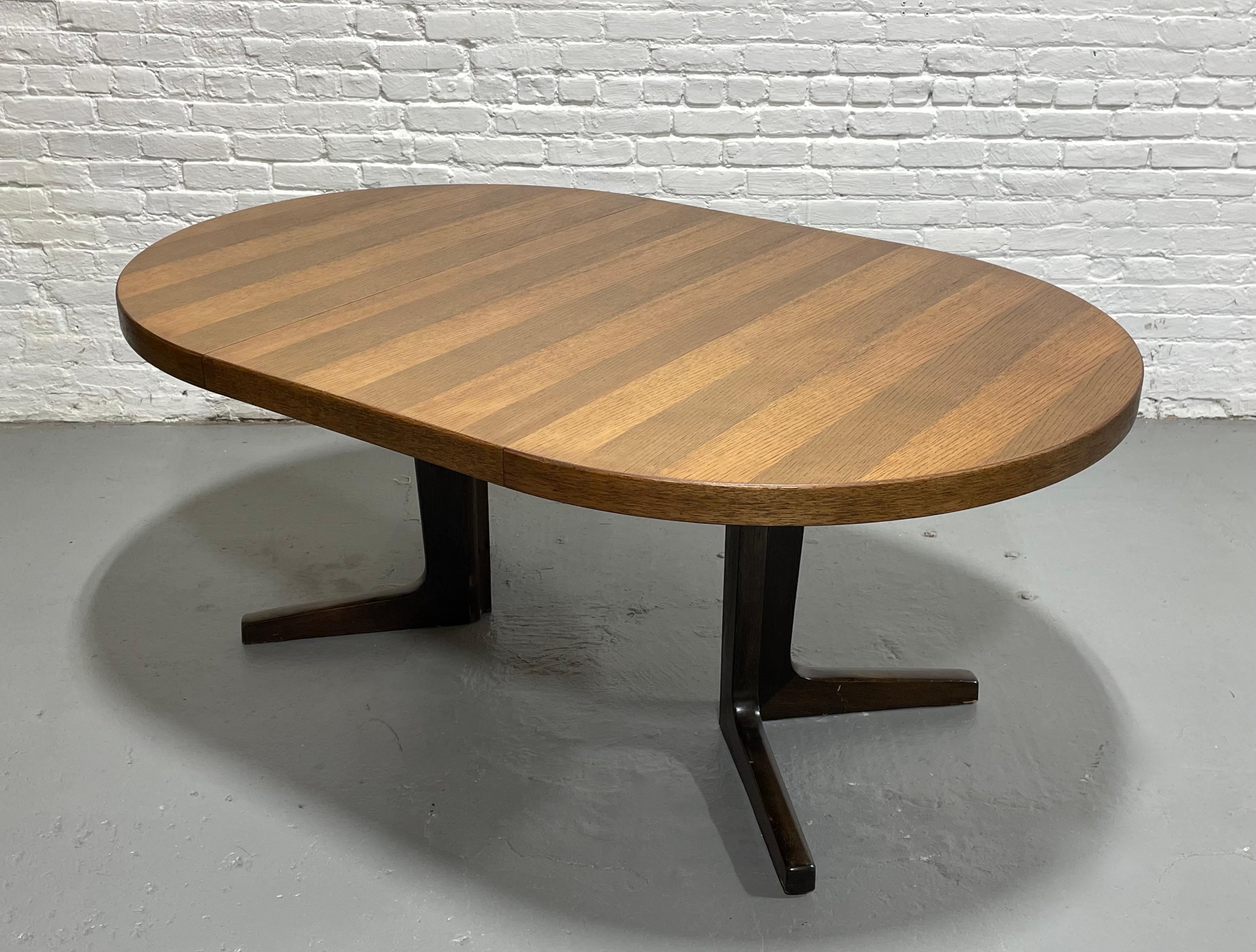 Mid Century Modern Oak + Rosewood Dining Table, c. 1960s. This pristine condition table transforms from a space saving round to a spacious oval dining table.  Absolutely gorgeous, finely crafted and newly refinished dining table that extends from a