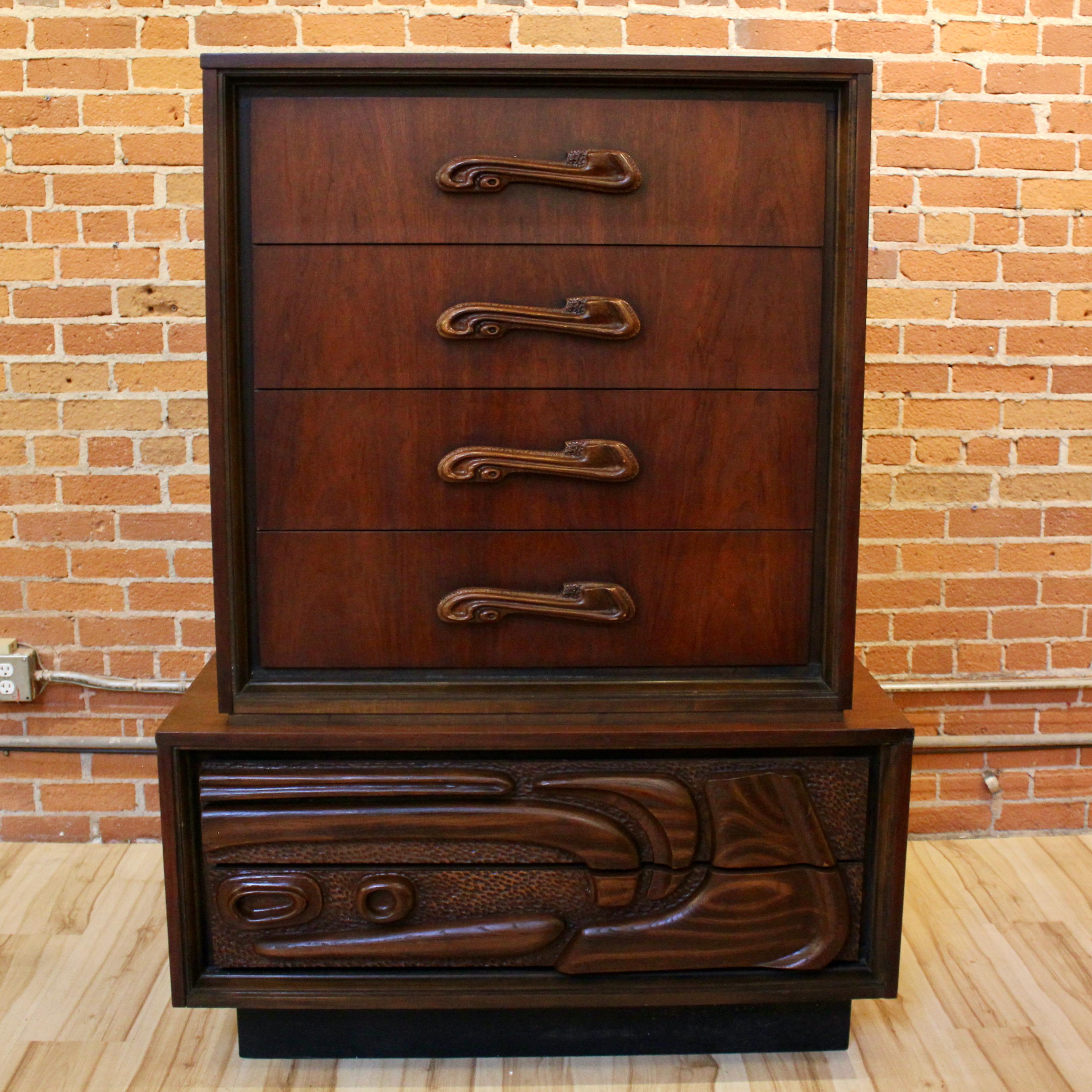 Mid-Century Modern “Oceanic” tall walnut chest of drawers by Pulaski Furniture. The chest has four drawers in the top section and three in the bottom, with carved detailing reminiscent of Paul Evans designs. In good vintage condition, with some wear