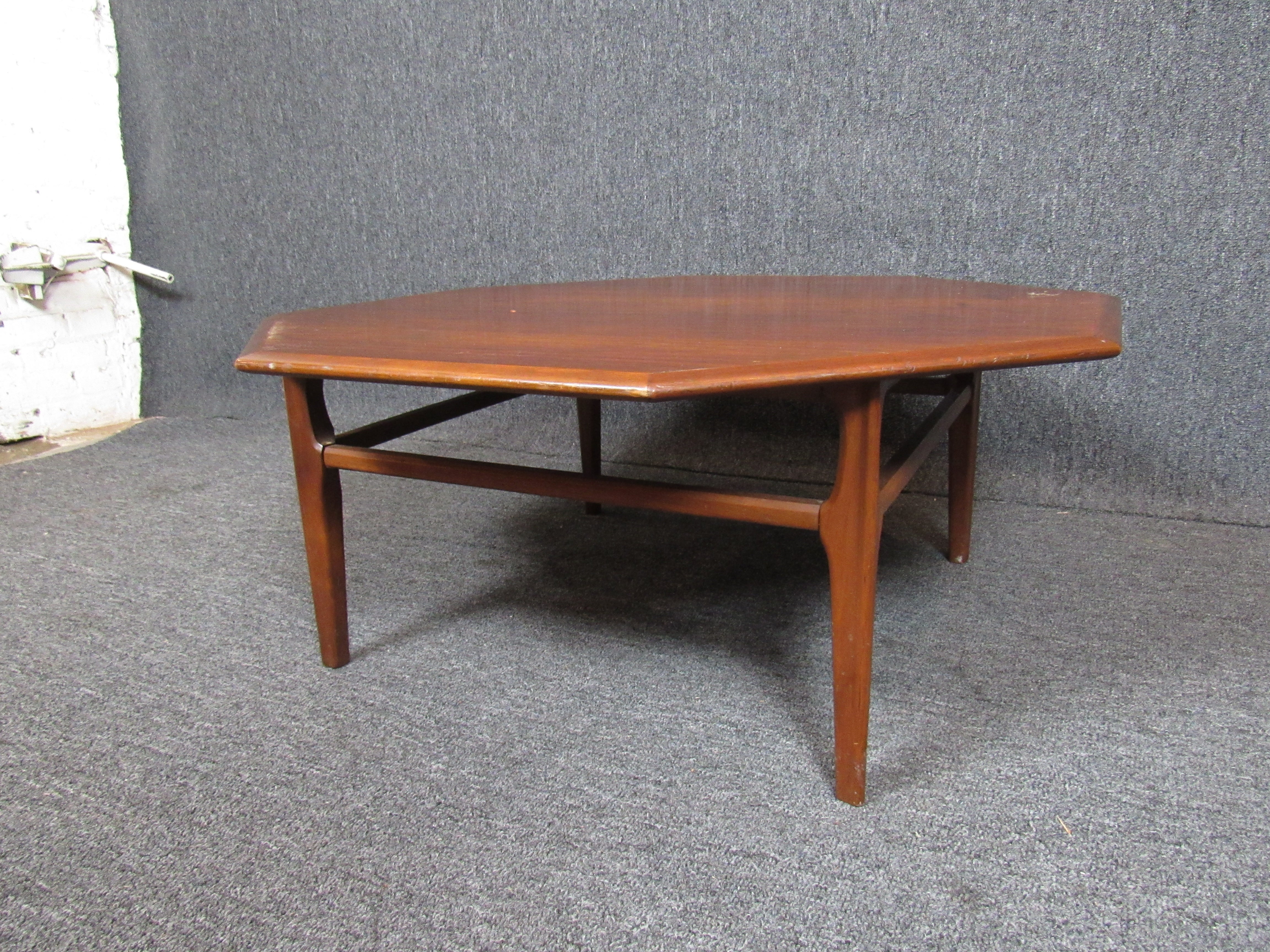 Nice mid-century table with a large octagonal top with plenty of room to kick up your feet and watch TV or to spread out the crossword puzzle alongside your morning coffee. Warm, wood finish that will compliment a wide variety of styles. (Please