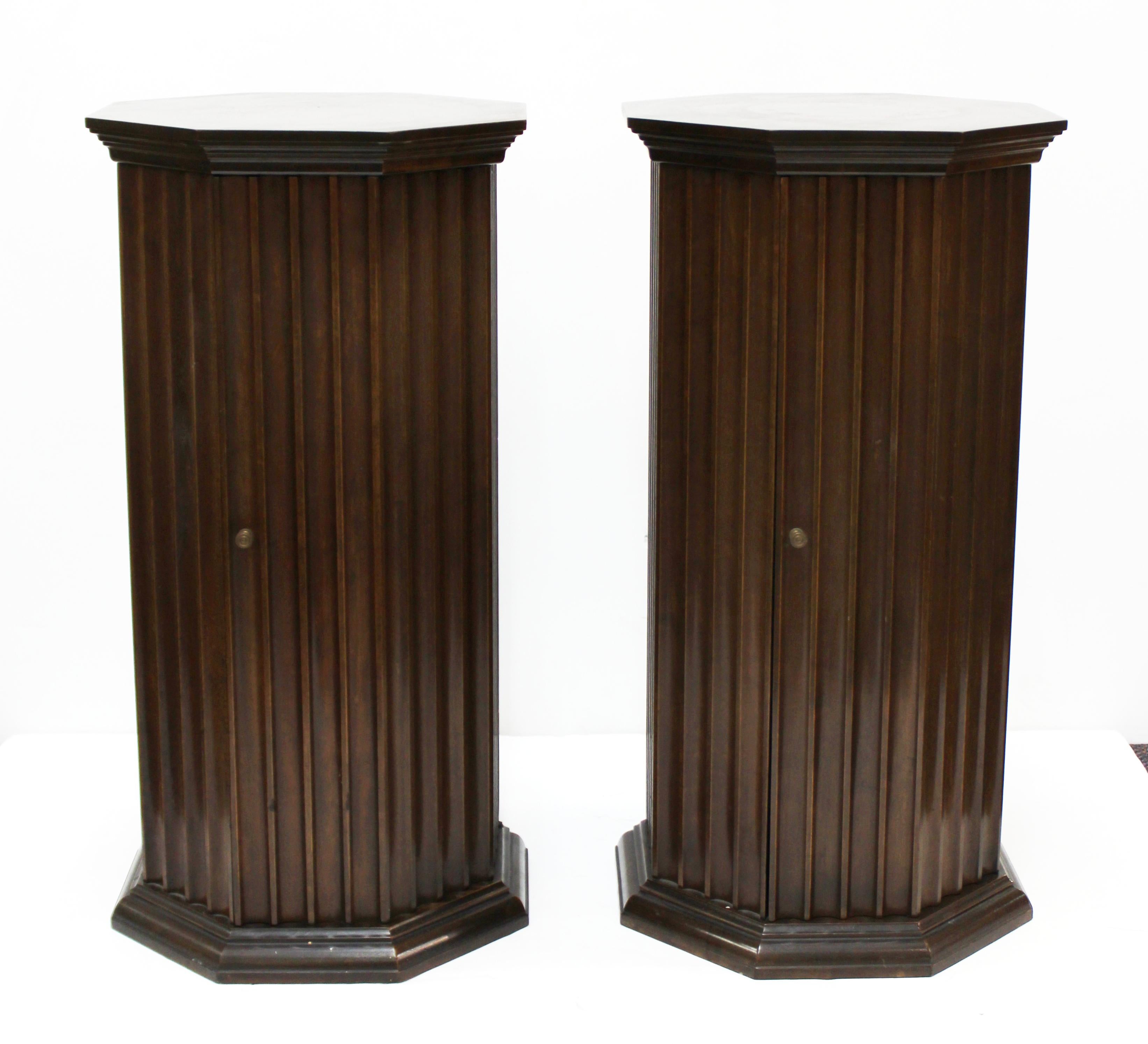 Mid-Century Modern octagonal fluted wood pedestals made from mahogany. Each pedestal has a door and one shelf on the interior. The pair was made in the United States in the 1970s and is in great vintage condition with age-appropriate wear and use.