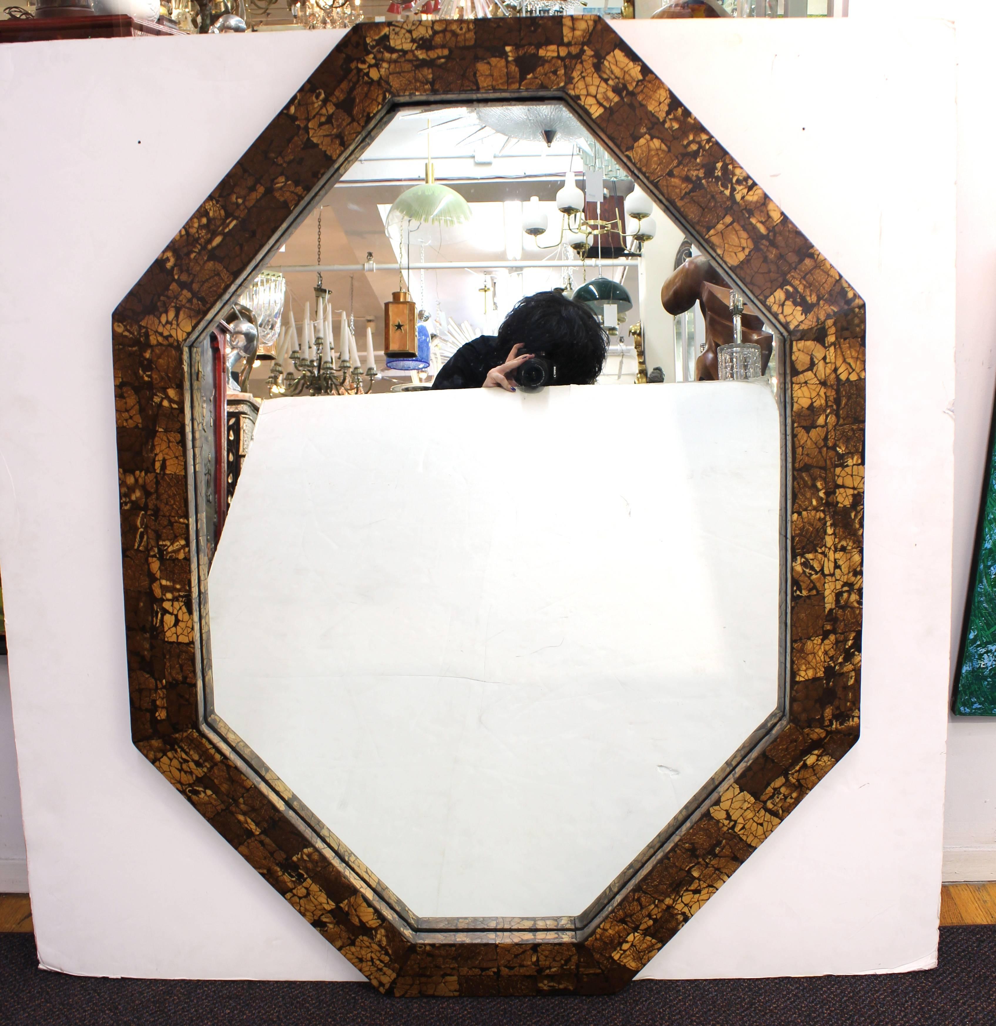 Mid-Century Modern octagonal wall mirror with tessellated surface. The piece is in good vintage condition with some minor cracks to the tessellated surfaces on the border.