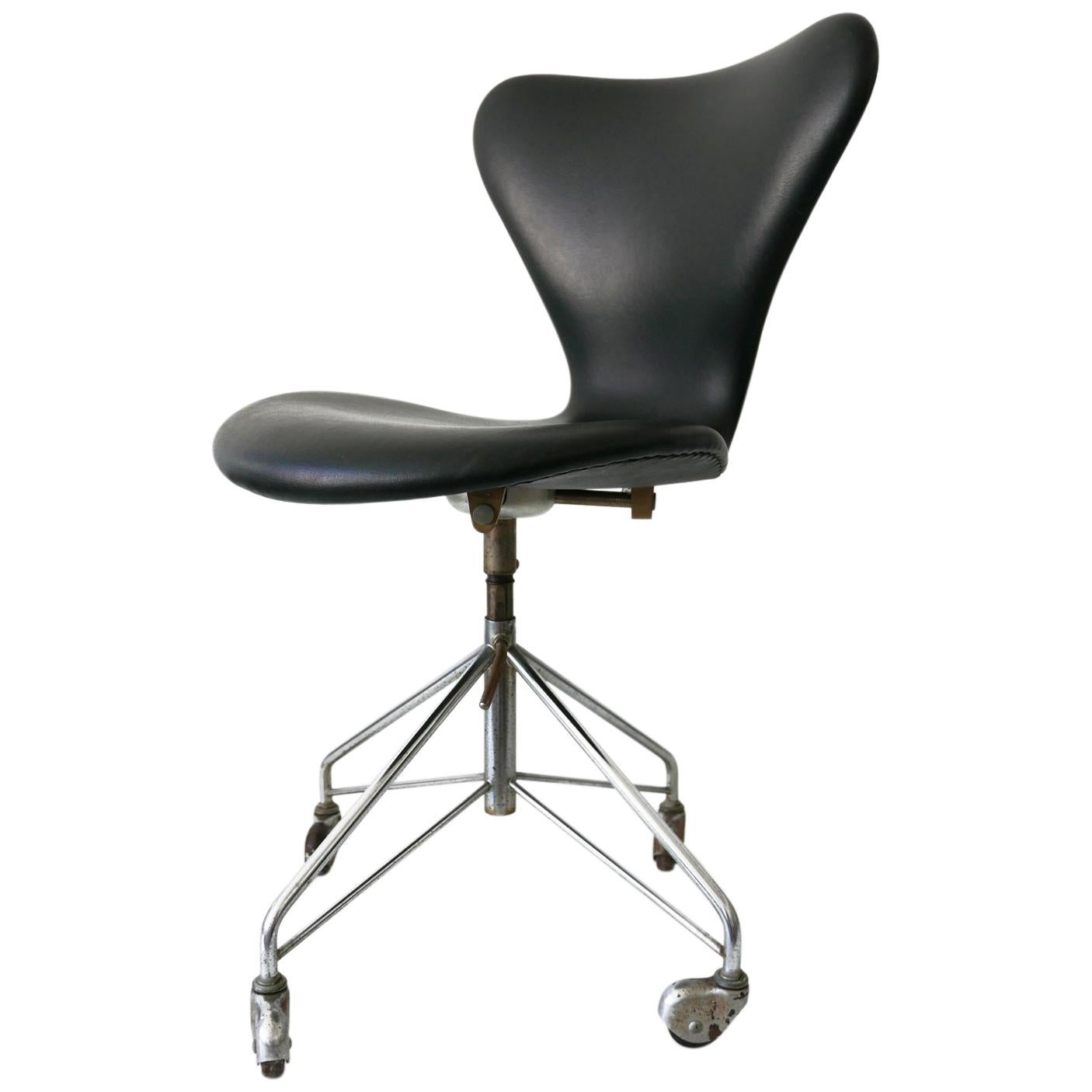 Rare Mid-Century Modern desk or office chair model 3117 with the rare four rolls base. Designed by Arne Jacobsen for Fritz Hansen. Produced in 1967. Adjustable height.

Executed in vinyl and chrome-plated steel.

Dimensions:
H 33.46 x D 19.68 x W