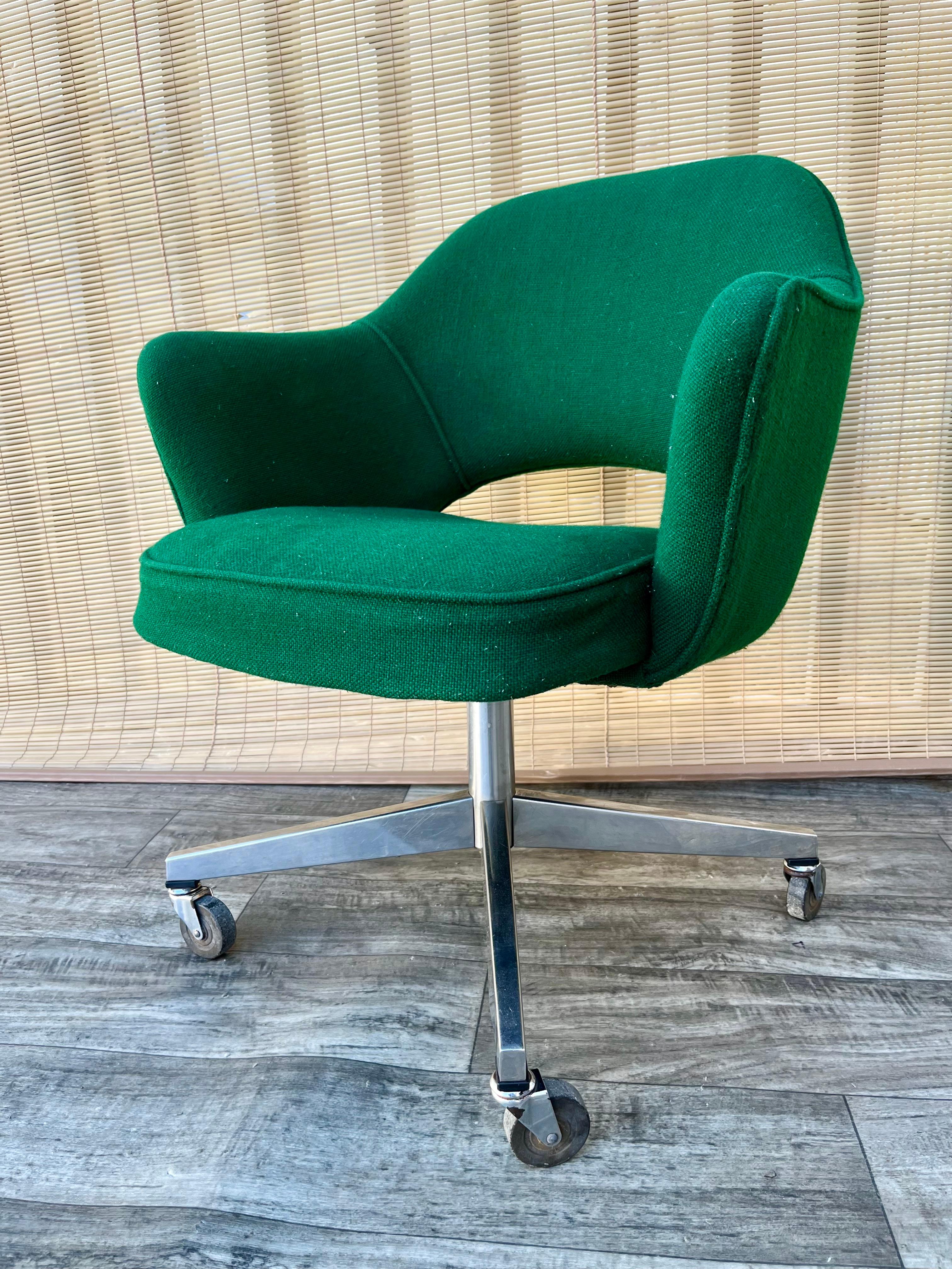 Vintage Mid Century Modern Office Chair with arms by Saarinen for Knoll. Circa 1970s 
Feature the original hunter green twill upholstery and casters for easy mobility.
The chair smoothly tilts and swivels.
In good original condition with signs of