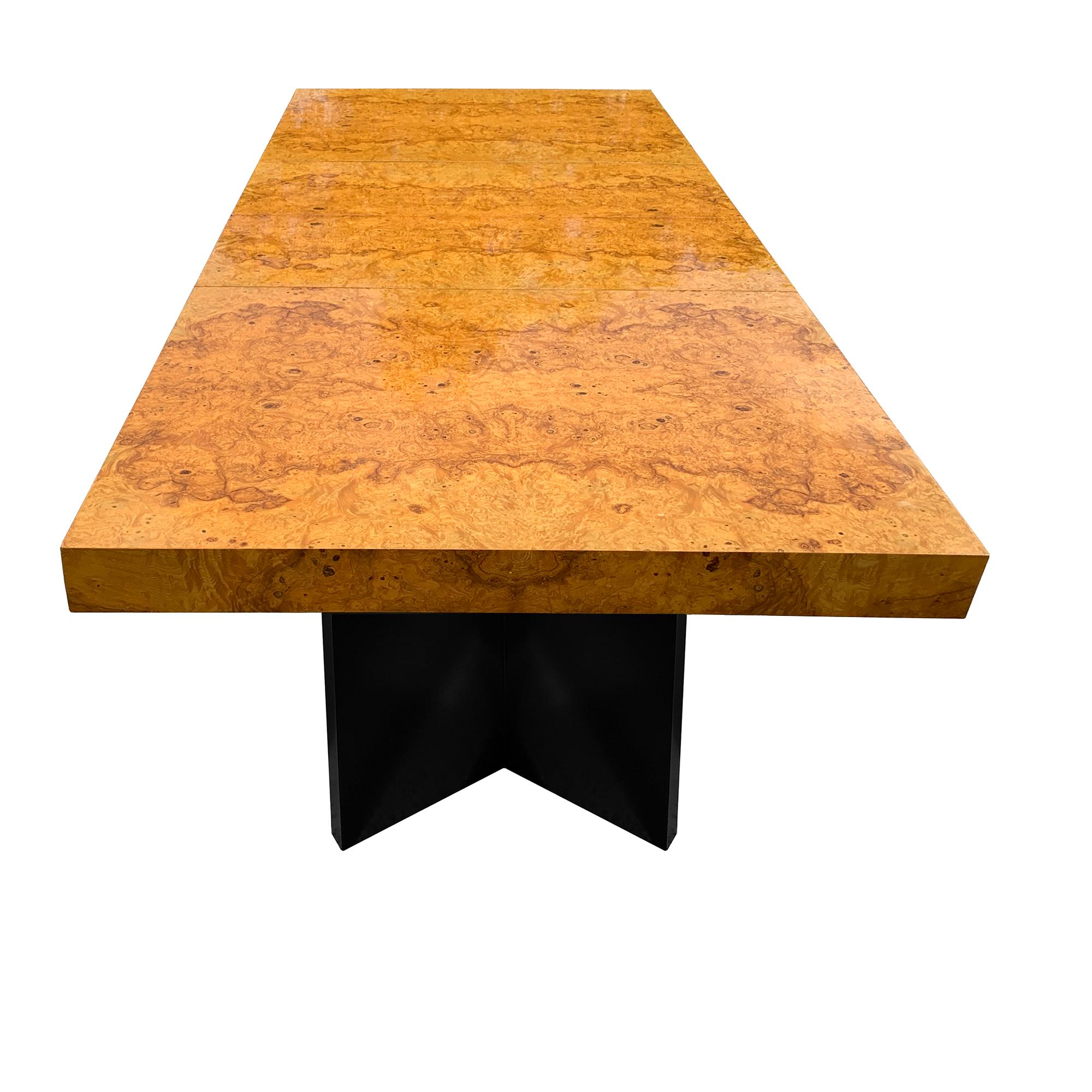 Gorgeous 1970s olive burl wood top extension dining table with black mid-century modern dual V shaped pedestal bases. Includes 2 leaves. The top is glossy and shows reflections in the photos. This table seats 6 without leaves, 8 with 1 leaf inserted