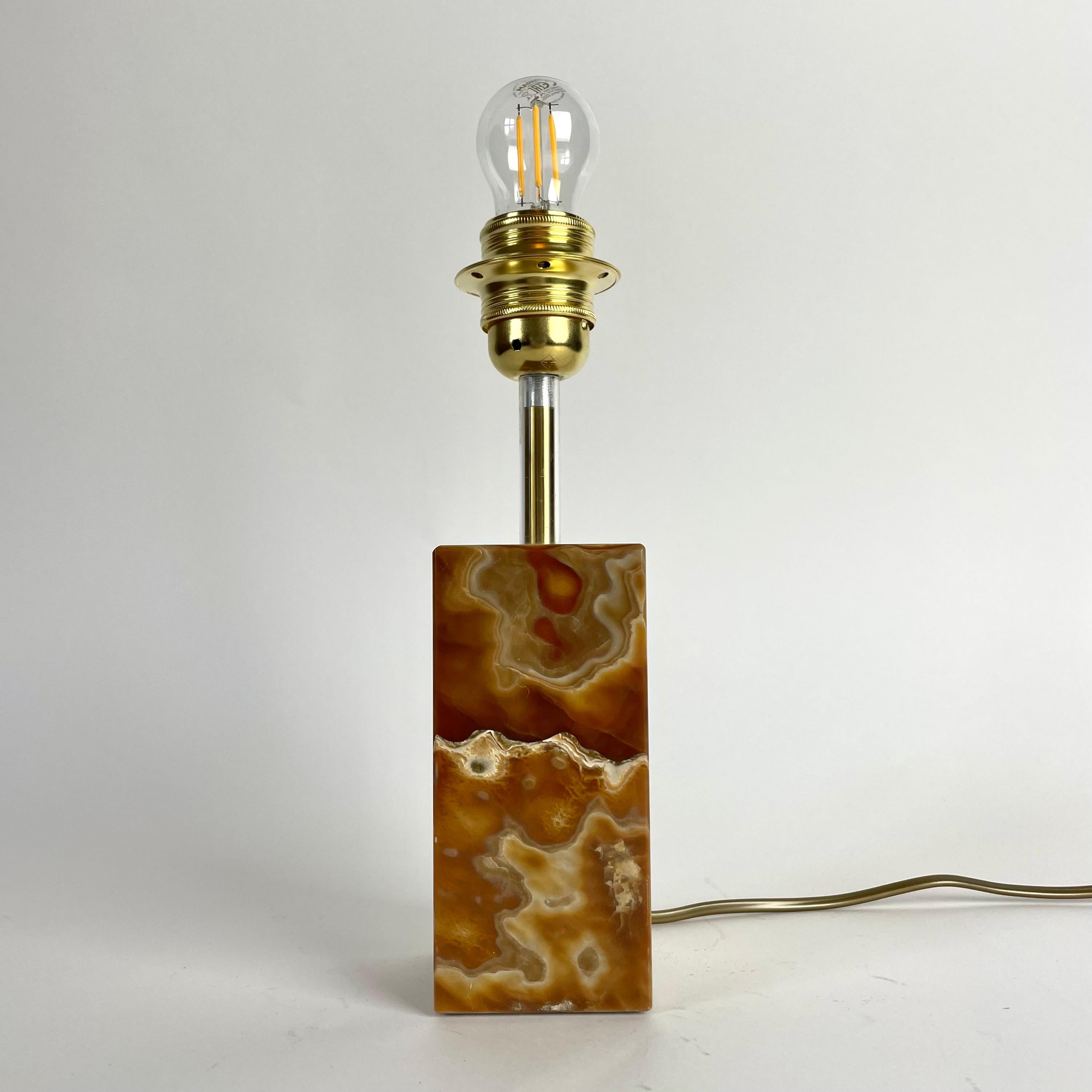 Elegante lampe de table des années 1960 au design moderne classique du milieu du siècle. La magnifique base en onyx présente des veines uniques et des variations de couleurs chaudes, ce qui confère à la lampe un aspect exclusif. La douille en laiton