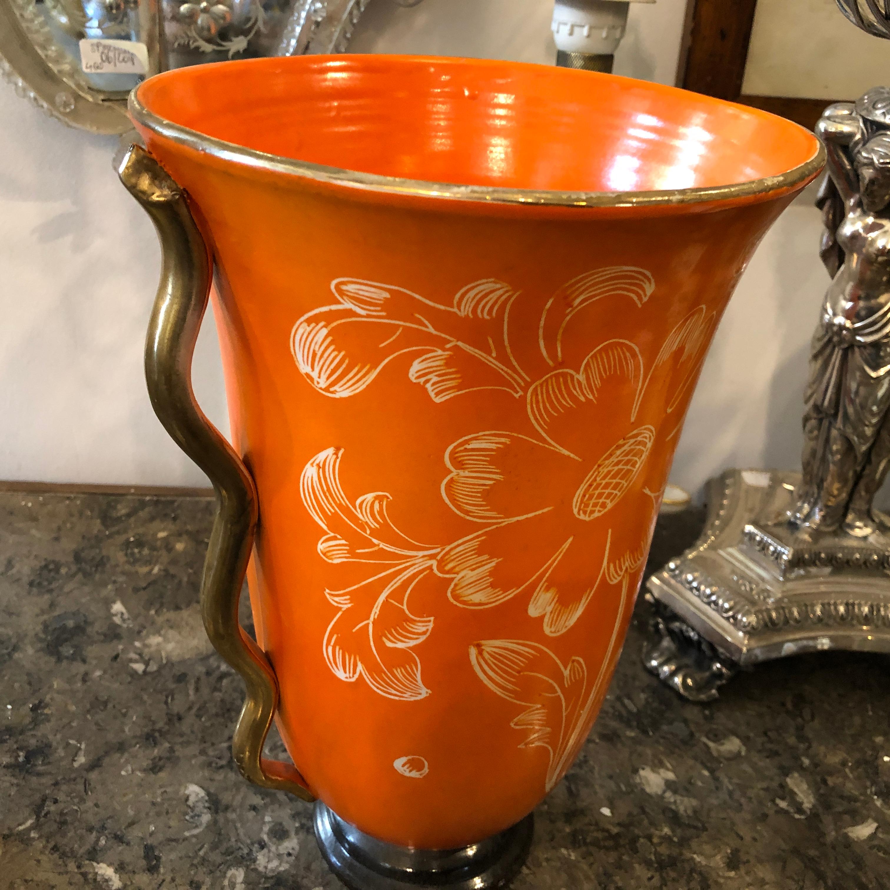 It's a rare vase made in Italy in the 1950s probably in Umbertide. Orange and gold ceramic, flowers decorated.