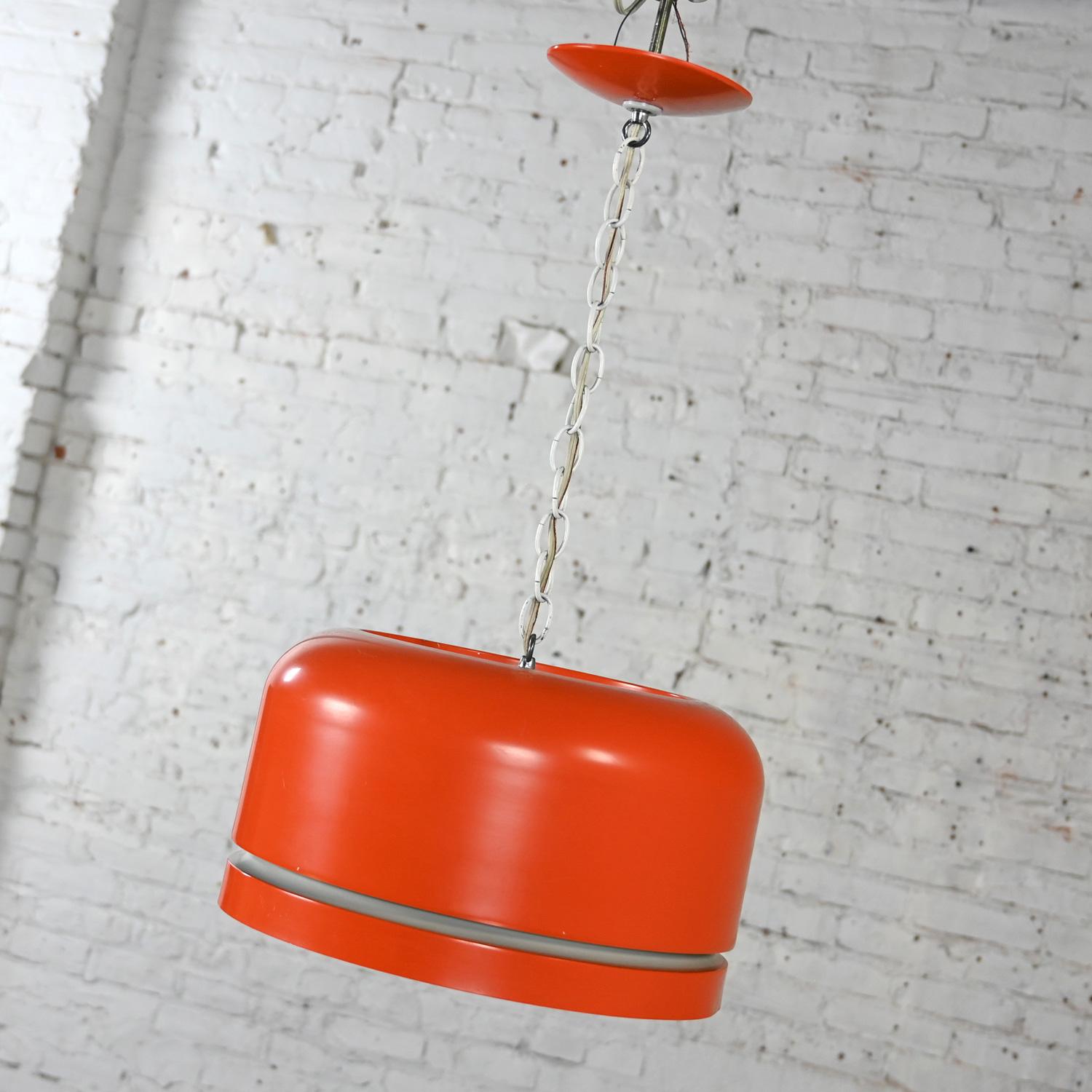 Marvelous vintage Mid-Century Modern orange dome or pendant hanging light fixture by Lightolier. Comprised of orange enameled metal, hardwired, 3 bulb socket, 3 way switch, white chain, and orange ceiling canopy. Beautiful condition, keeping in mind