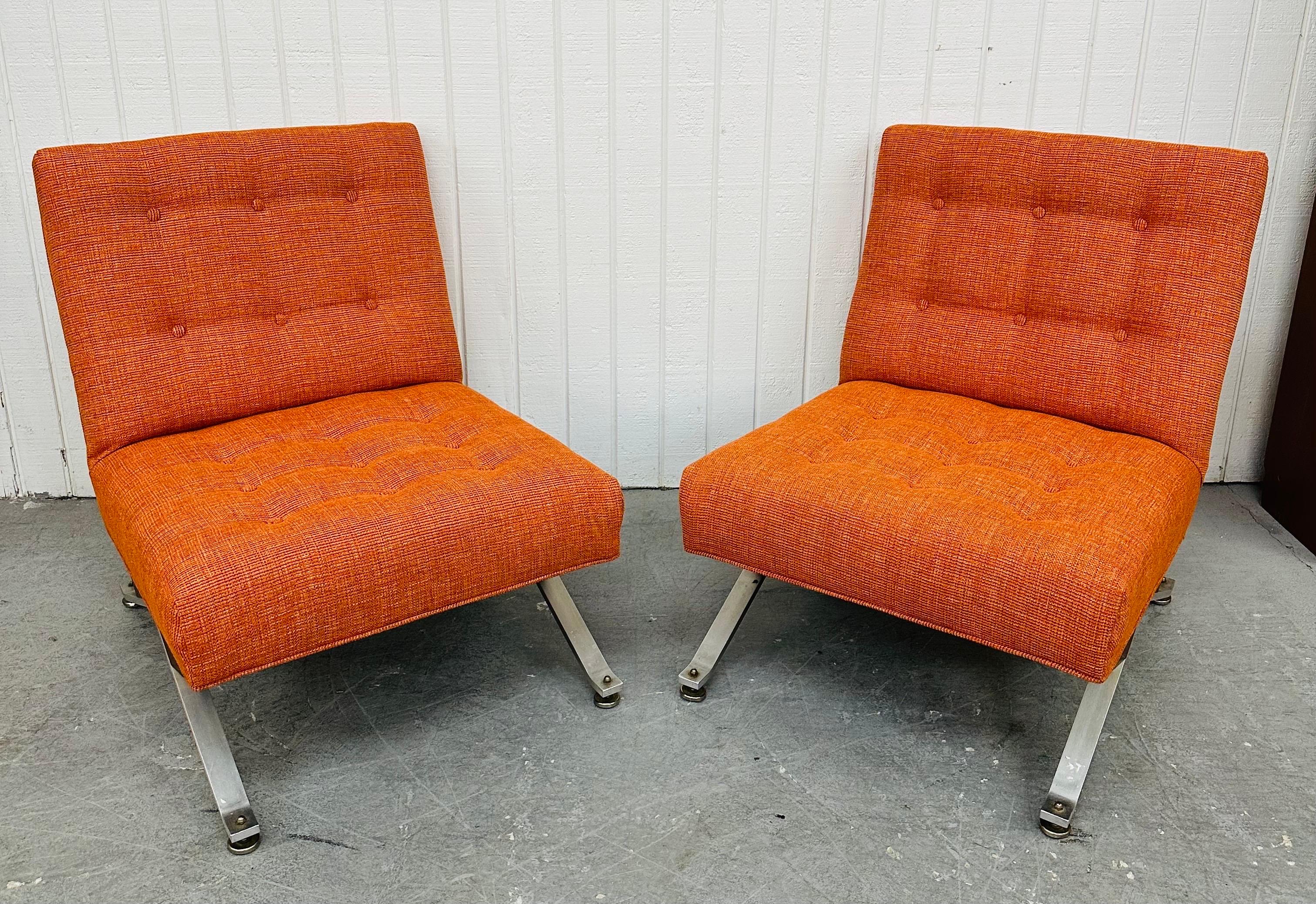 This listing is for a pair of Mid-Century Modern Orange Slipper Chairs. Featuring an armless slipper design, bent aluminum legs, walnut accents on each side, and newly re-done orange upholstery. This is an exceptional combination of quality and