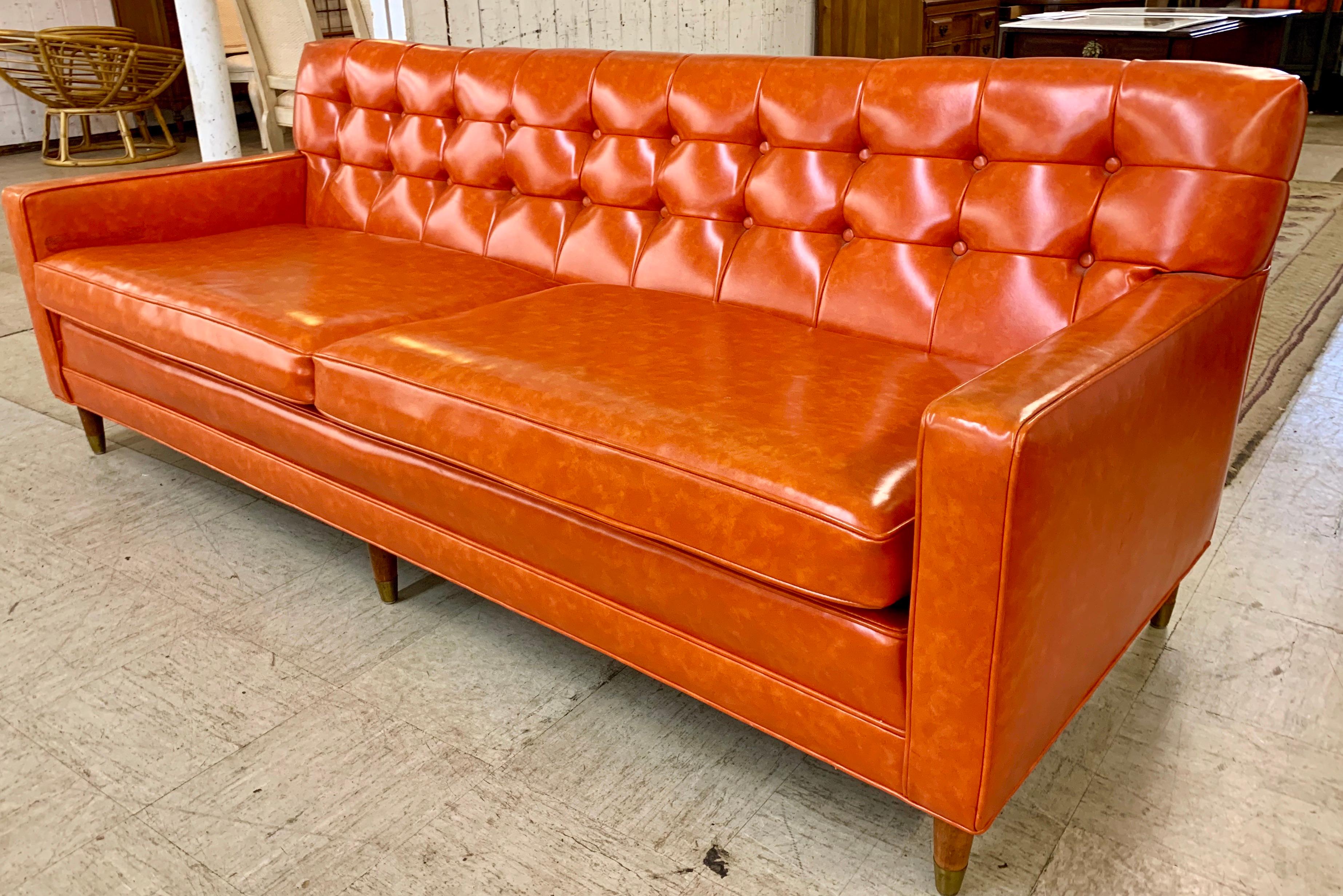 Great Mid-Century Modern period piece with all original orange vinyl upholstery and button tufted back.