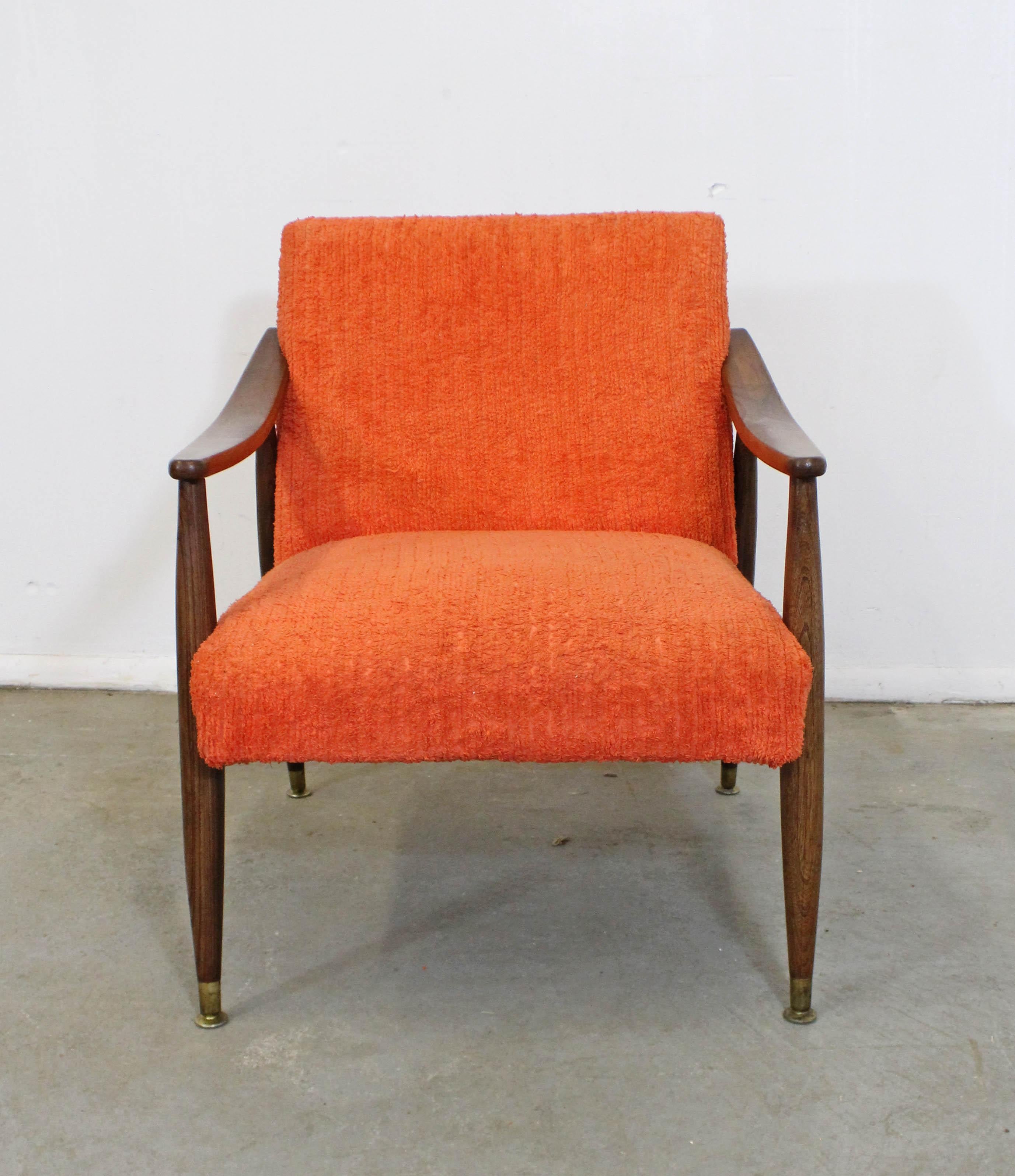 What a find. Offered is a vintage Mid-Century Modern lounge chair made of walnut and textured orange upholstery. This chair has wonderful lines, is in structurally sound condition with a refinished frame. The fabric shows some age wear, but no tears