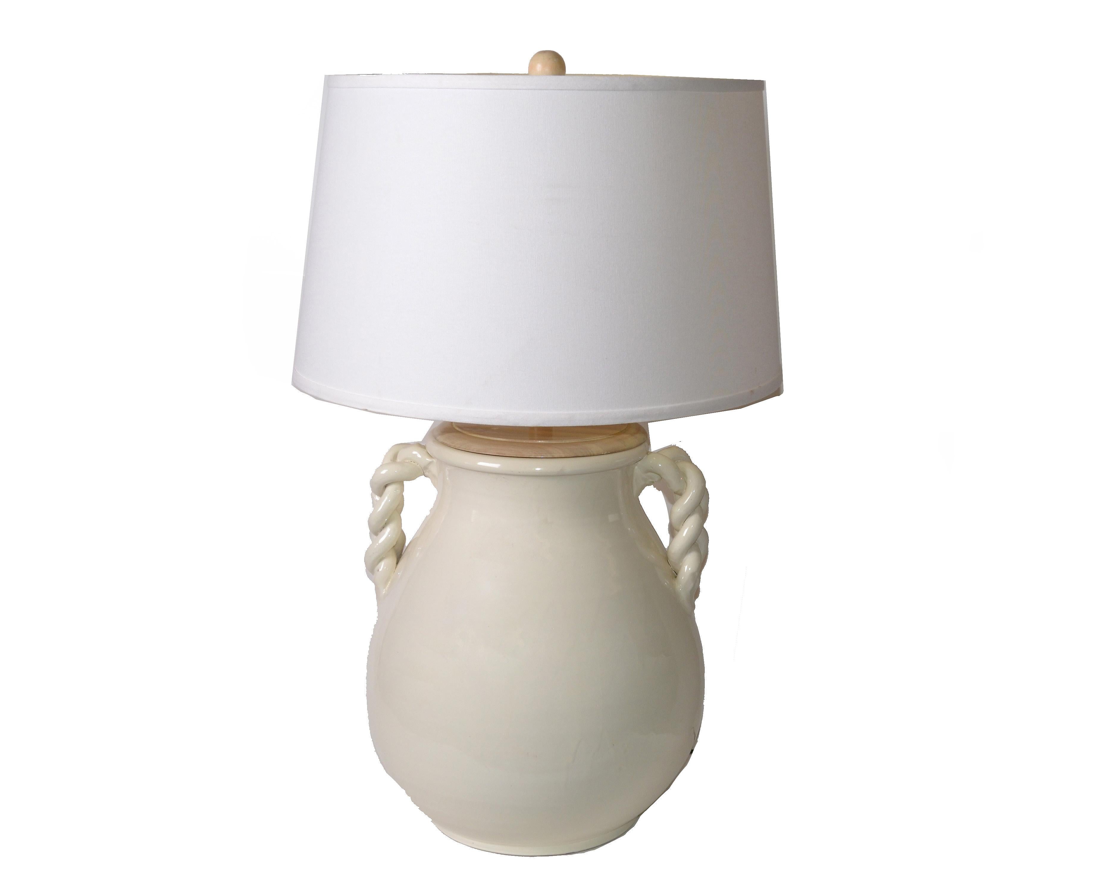 Gorgeous American Mid-Century Modern glazed beige ceramic table lamp.
Braided handles and it comes with round linen lamp shade, harp and wood finial.
Wired for the U.S. and uses a max. 75 watts light bulb.
Dimensions shade:
Height 12.25