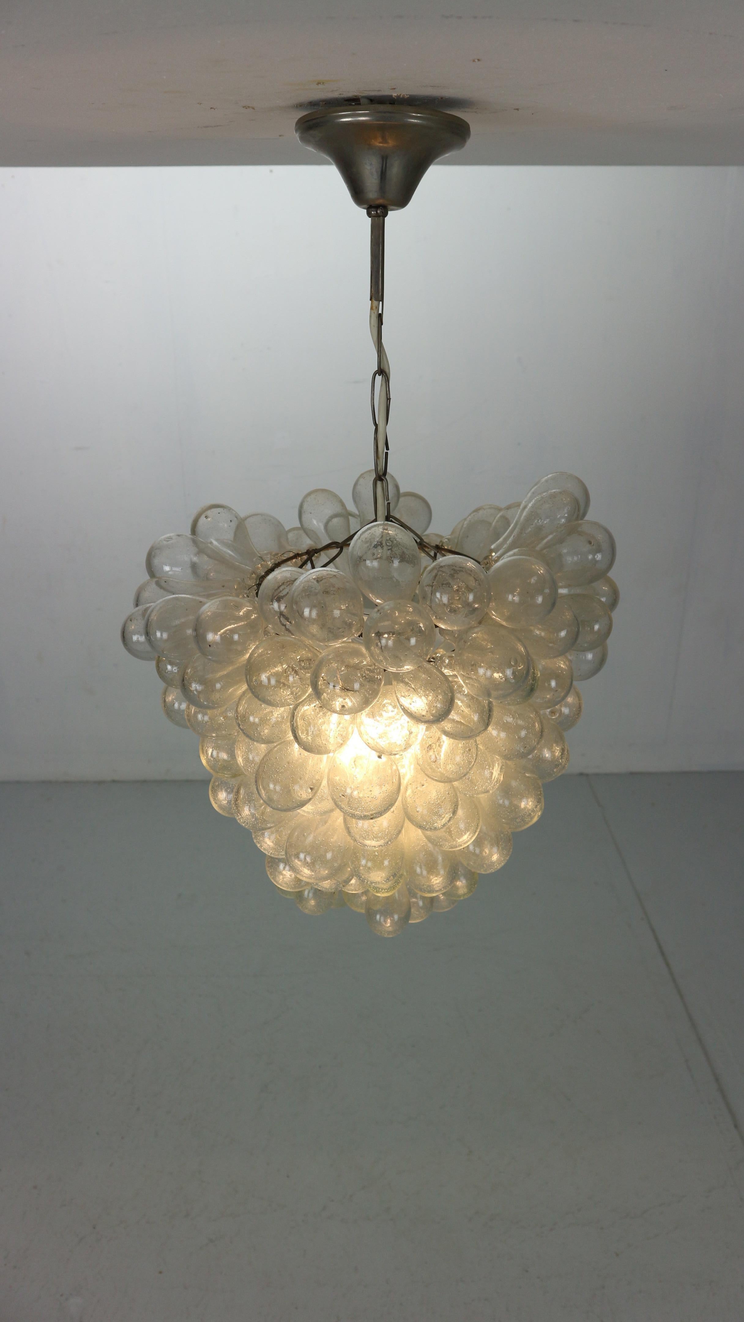 Stunning clear glass grape ceiling light hand-made from 100% recycled glass in 1930's Italy.

Each delicate grape is hand-blown in Damascus by traditional craftsmen and mounted on a metal frame to create dozens of unique, individually created