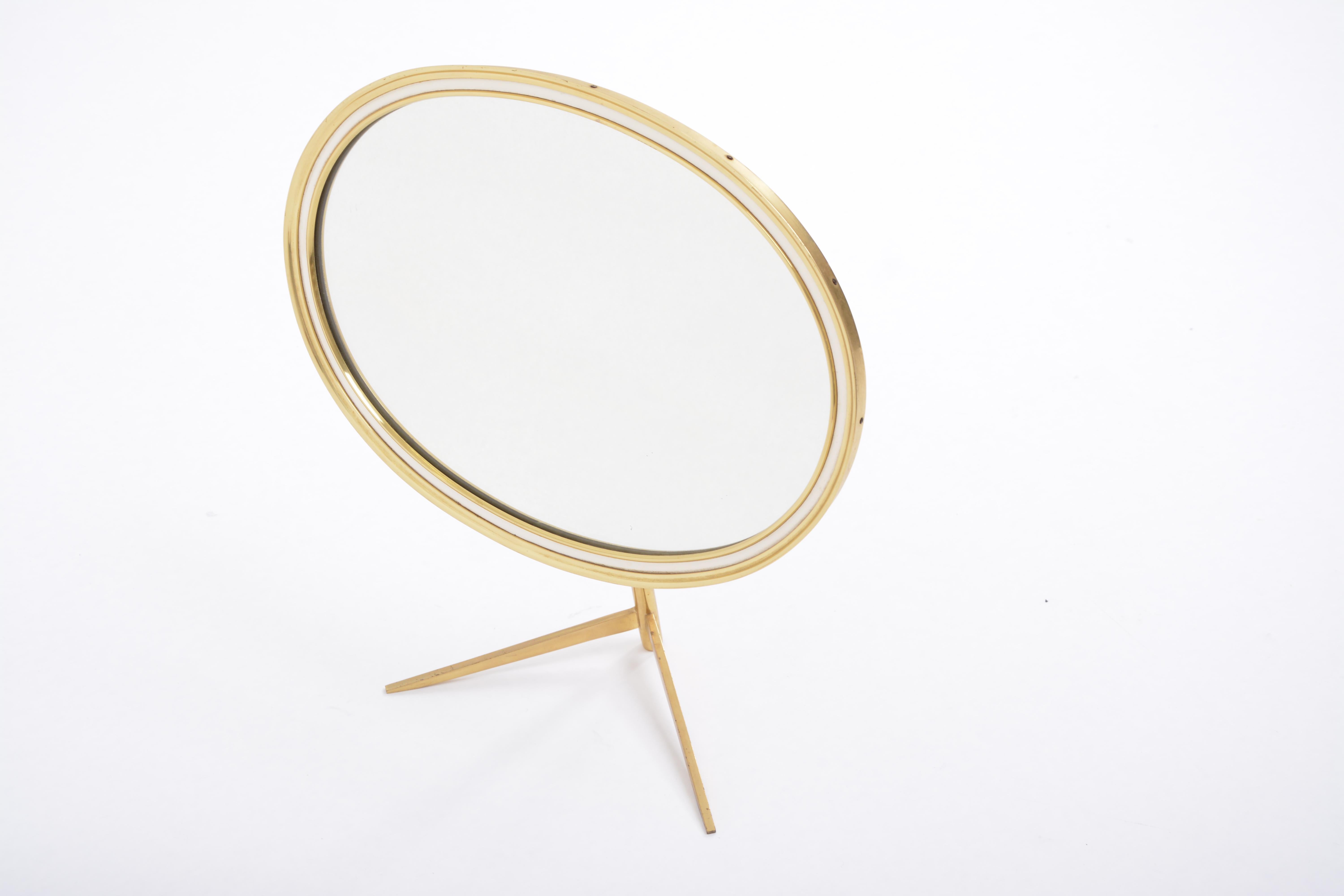 Mid-Century Modern oval brass table mirror by Vereinigte Werkstätten
This Mid-Century Modern table mirror features a solid brass stand and frame. The mirror can be adjusted to the desired angle.
The backside of this table mirror is covered with