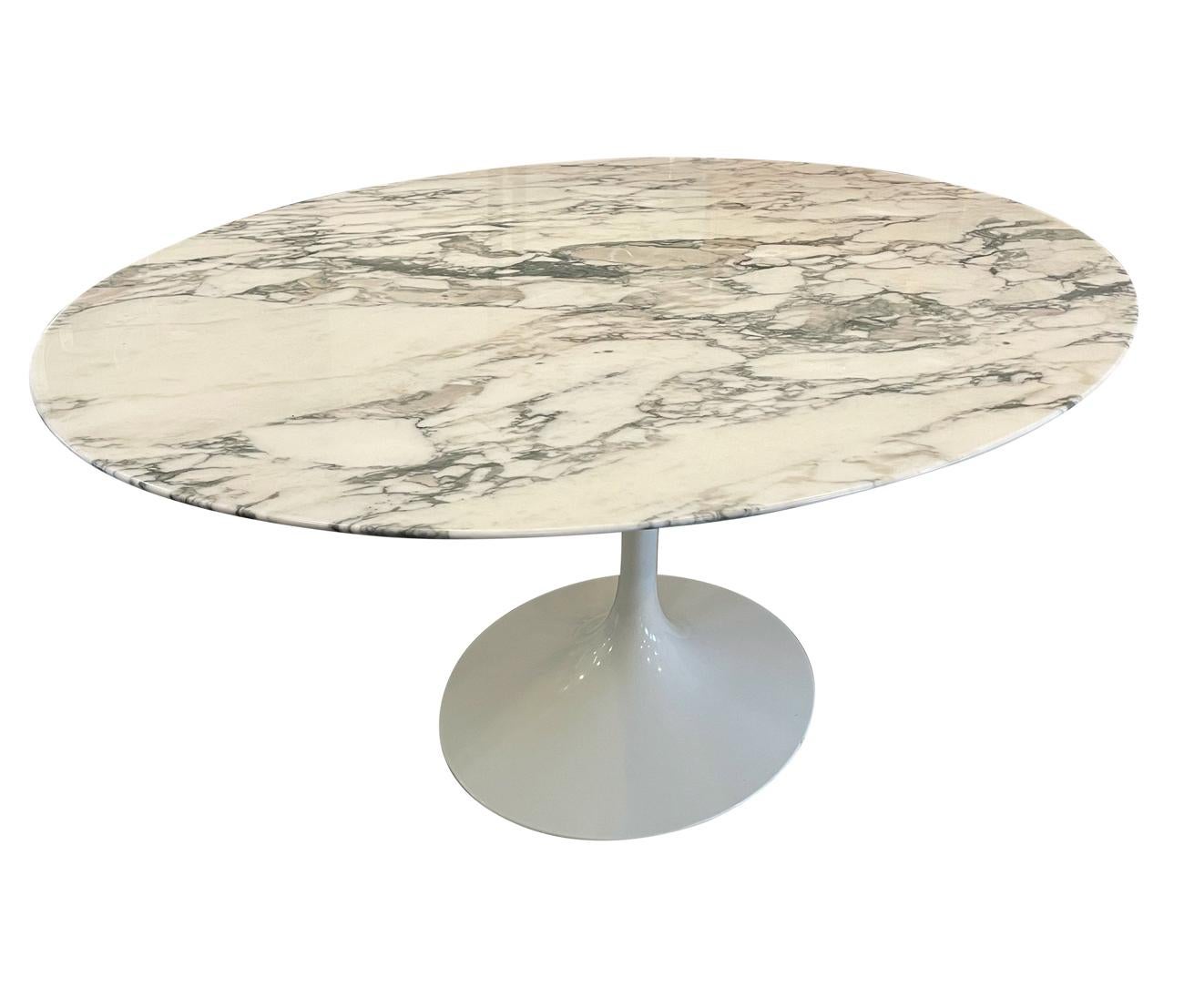 A large and impressive dining table designed by Eero Saarinen and produced by Knoll. This elliptical oval table features a beautiful slab of Arabescato marble on a white tulip base. Signed Eero Saarinen. Very well cared for and ready to use