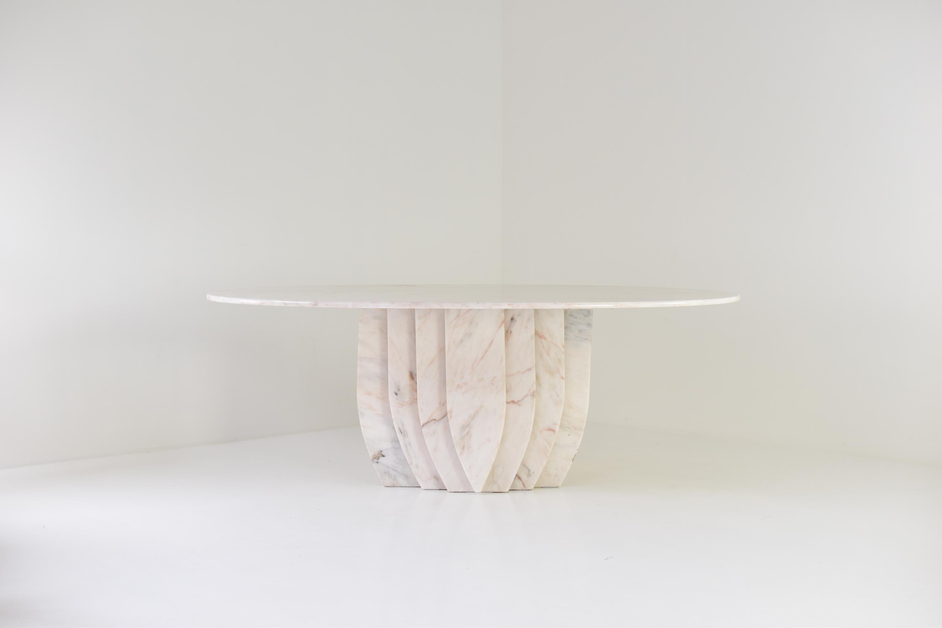 Mid-Century Modern oval dining table in marble from Italy, 1980’s. This table is fully made out of marble with variegated tones of white, brown and pink. Nicely sculptural shaped base. Masterpiece !