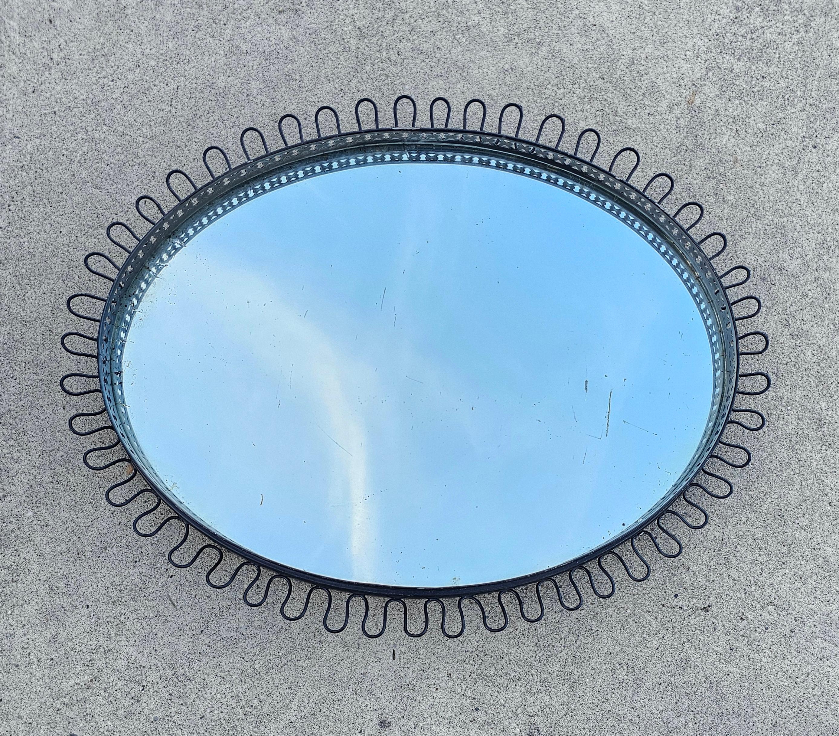 In this listing you will find beautiful and rare Mid Century Modern Oval Sunburst Mirror designed by Josef Frank. It comes with a black metal frame and the rope that allow you to mount it on the wall. Made in West Germany in 1960s.

Good vintage