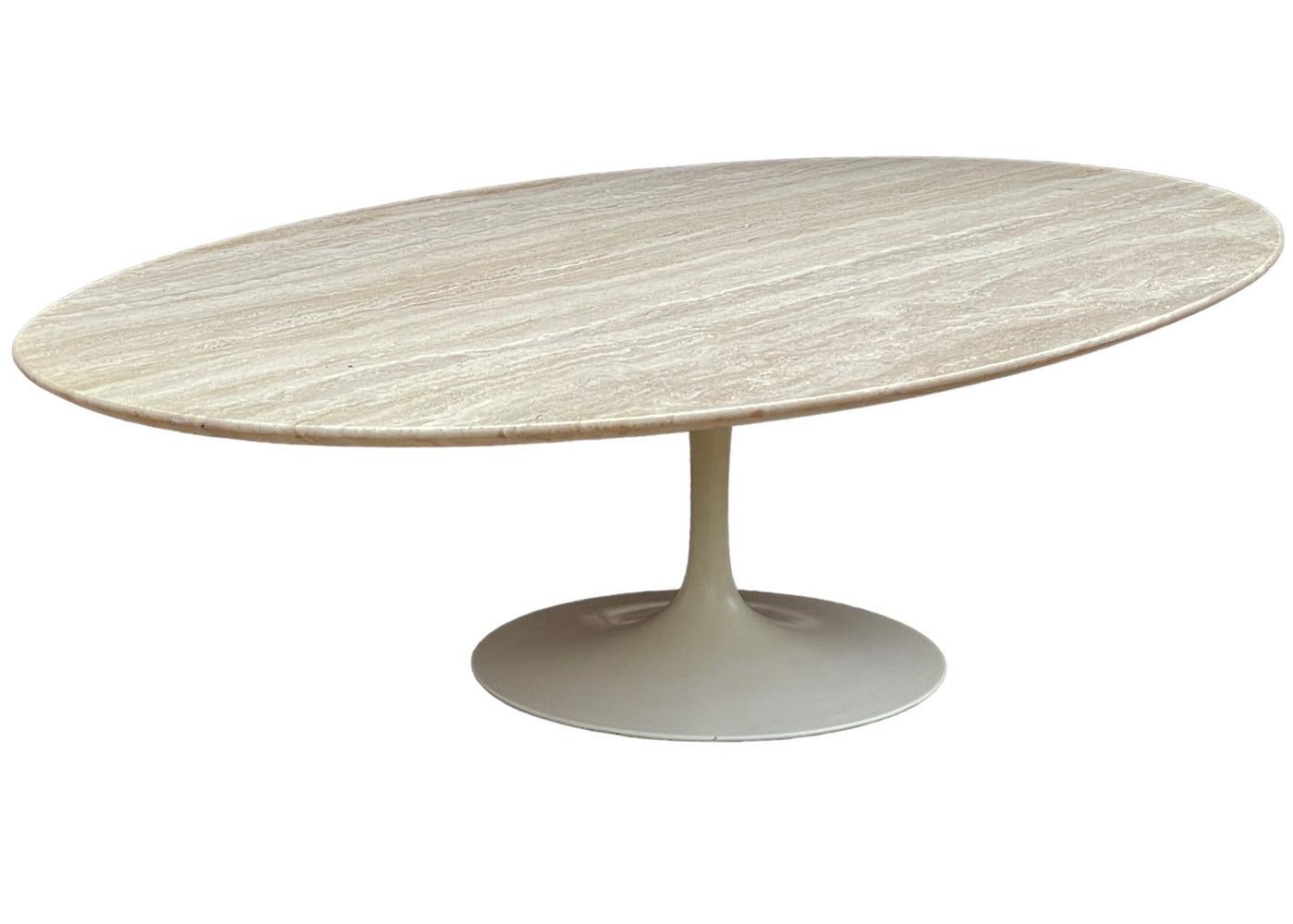 Early made oval coffee table designed by Eero Saarinen and produced by Knoll in the 60's. Excellent overall condition with beautiful beige travertine slab type and powder coated tulip base. 