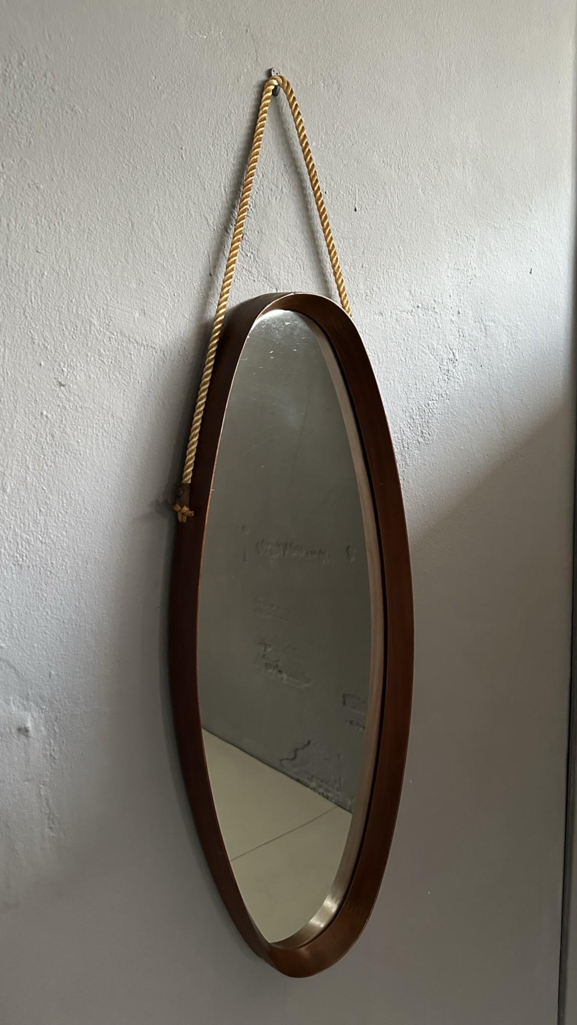 
Vintage oval mirror, with 1960s teak frame, Italian manufacturing.
The mirror has a rope for hanging on the wall.