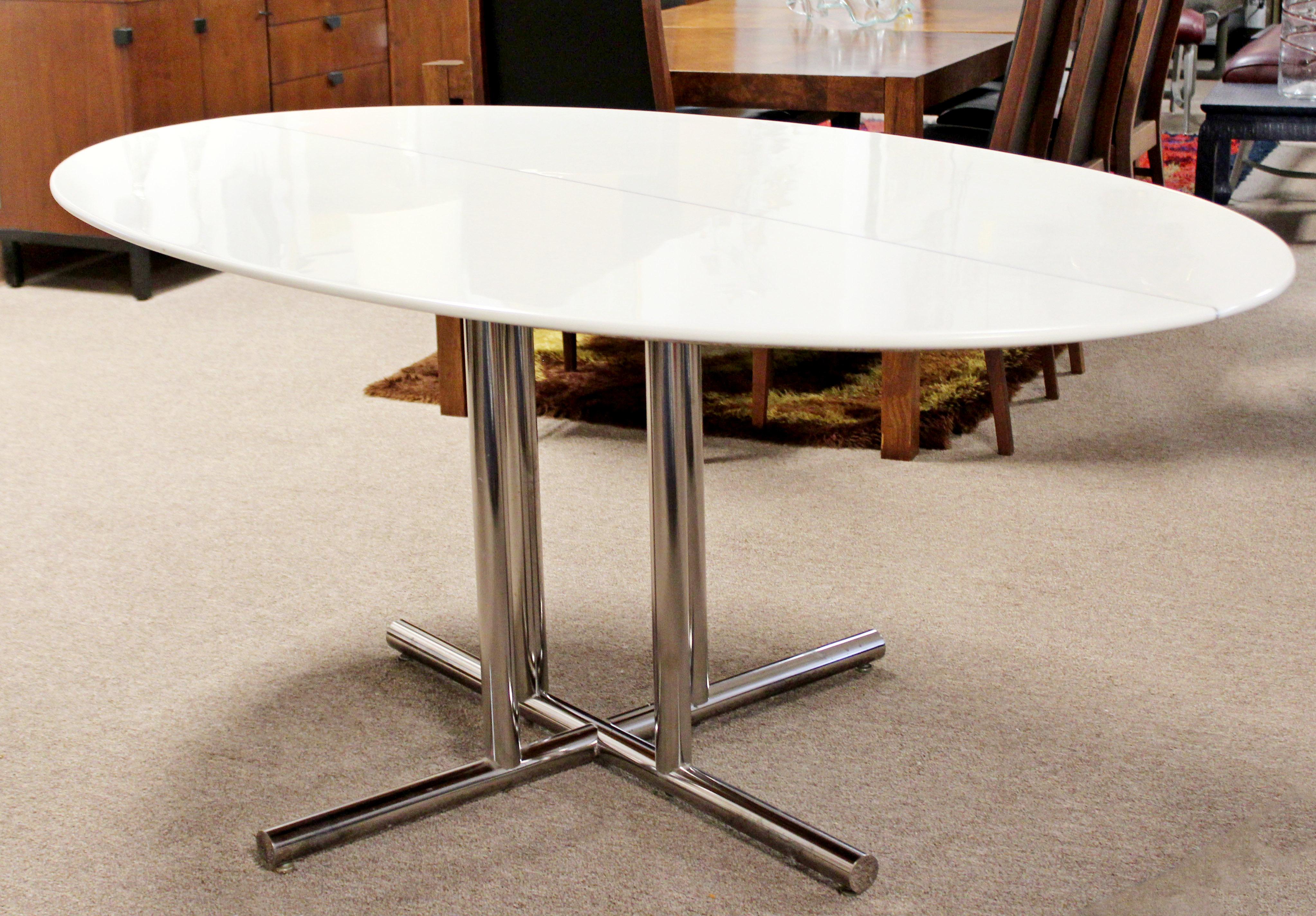 For your consideration is a phenomenal dining table, which features an ovular, vitrolite style surface on a sculptural, tubular chrome base. In very good condition. The dimensions are 72