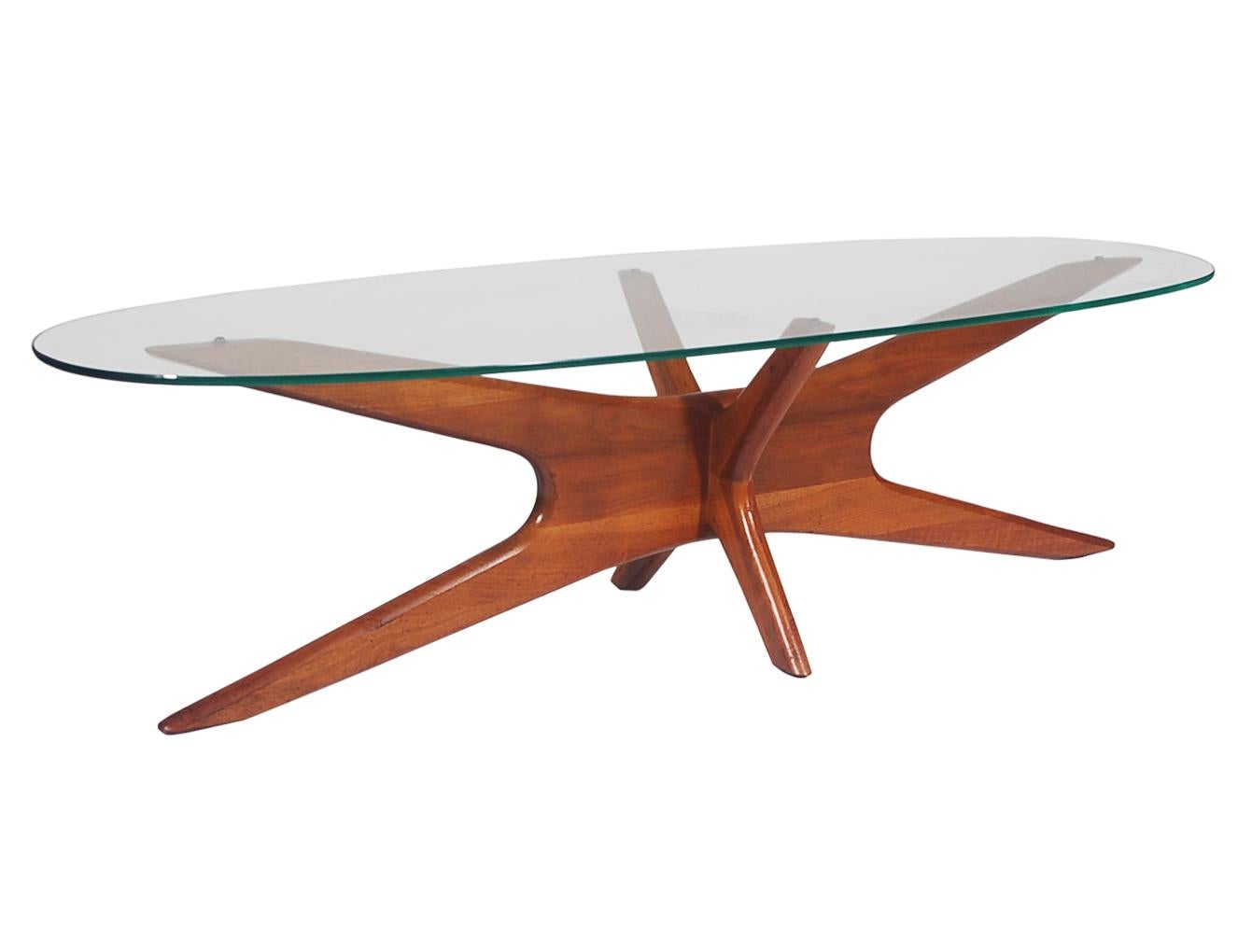 A Classic design by a Classic American designer and furniture builder, Adrian Pearsall. This table features an elongated oval glass top with a sculpted solid walnut base. Very well cared for through the years.