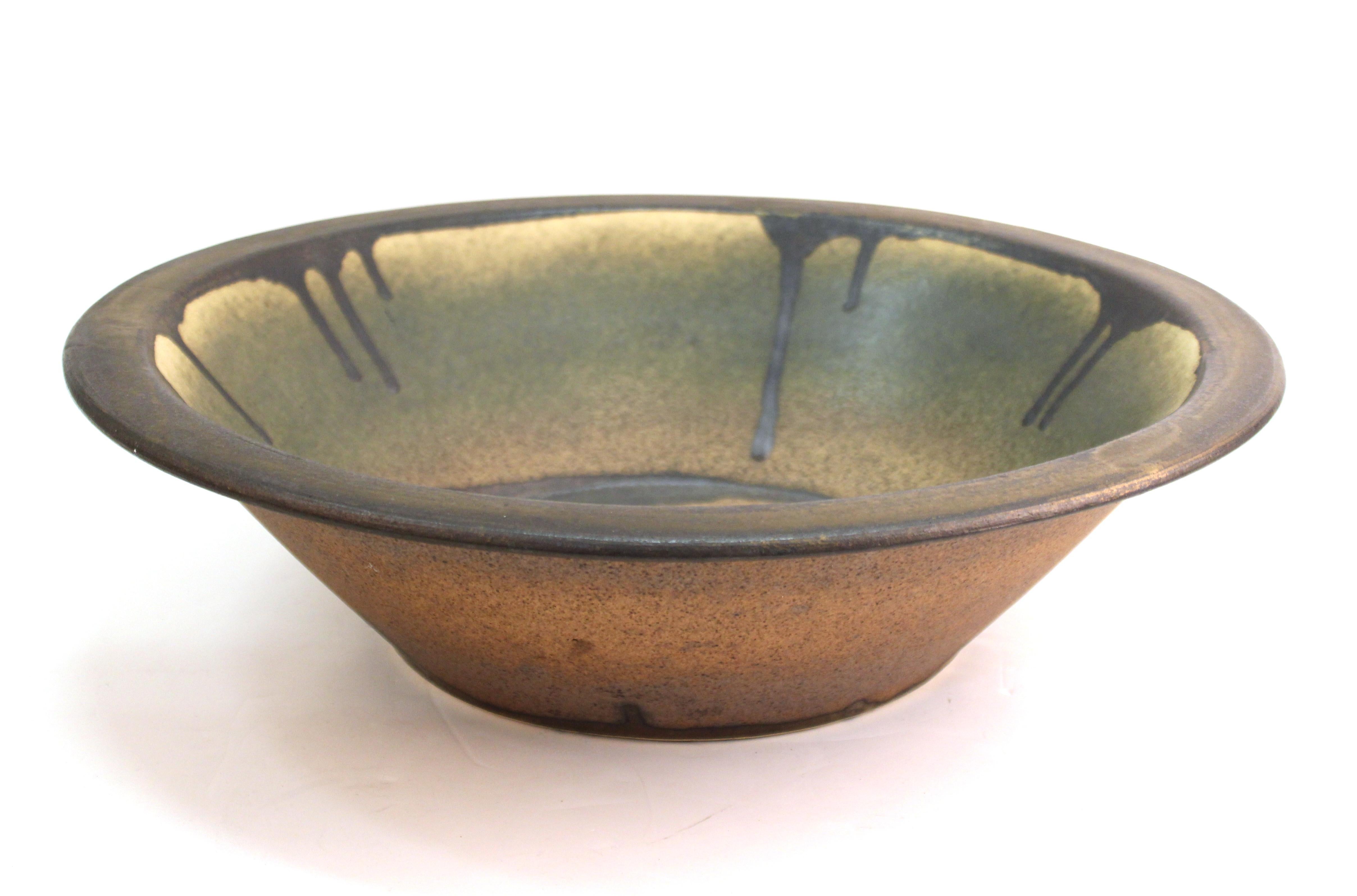 Mid-Century Modern oversized centerpiece pottery charger or bowl. The piece has a drip glaze on the rim and in the center and was made during the mid-20th century. In great vintage condition with age-appropriate wear.
