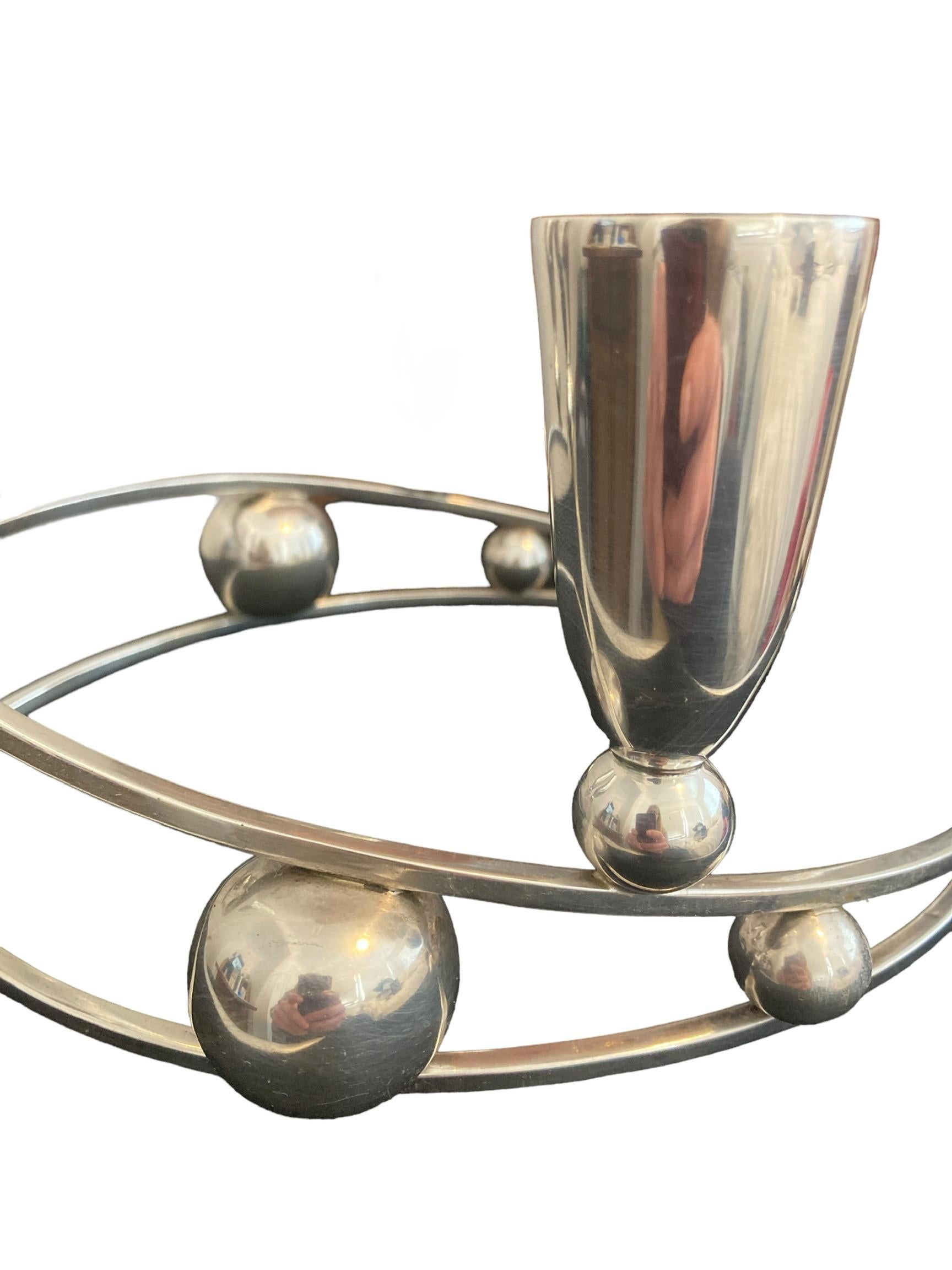 This highly desirable and sought after pair of Mid-Century Modernist P Lopez G sterling silver candelabra candlesticks was made in Mexico, circa 1950. Each piece design is of a stylized curvilinear sphere style, with three tulip-shaped candleholders