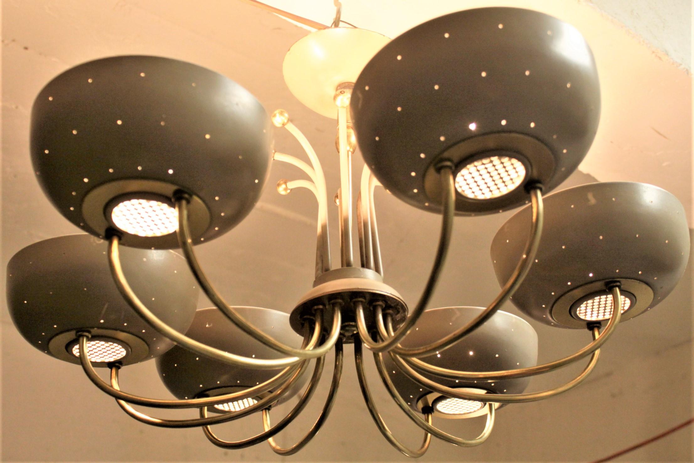 This Mid-Century Modern light fixture is unsigned, but believed to have been designed by Paavo Tynell of Finland in circa 1967. The chandelier features six cups, each supported by two brass finished arms which extend to the central post of the