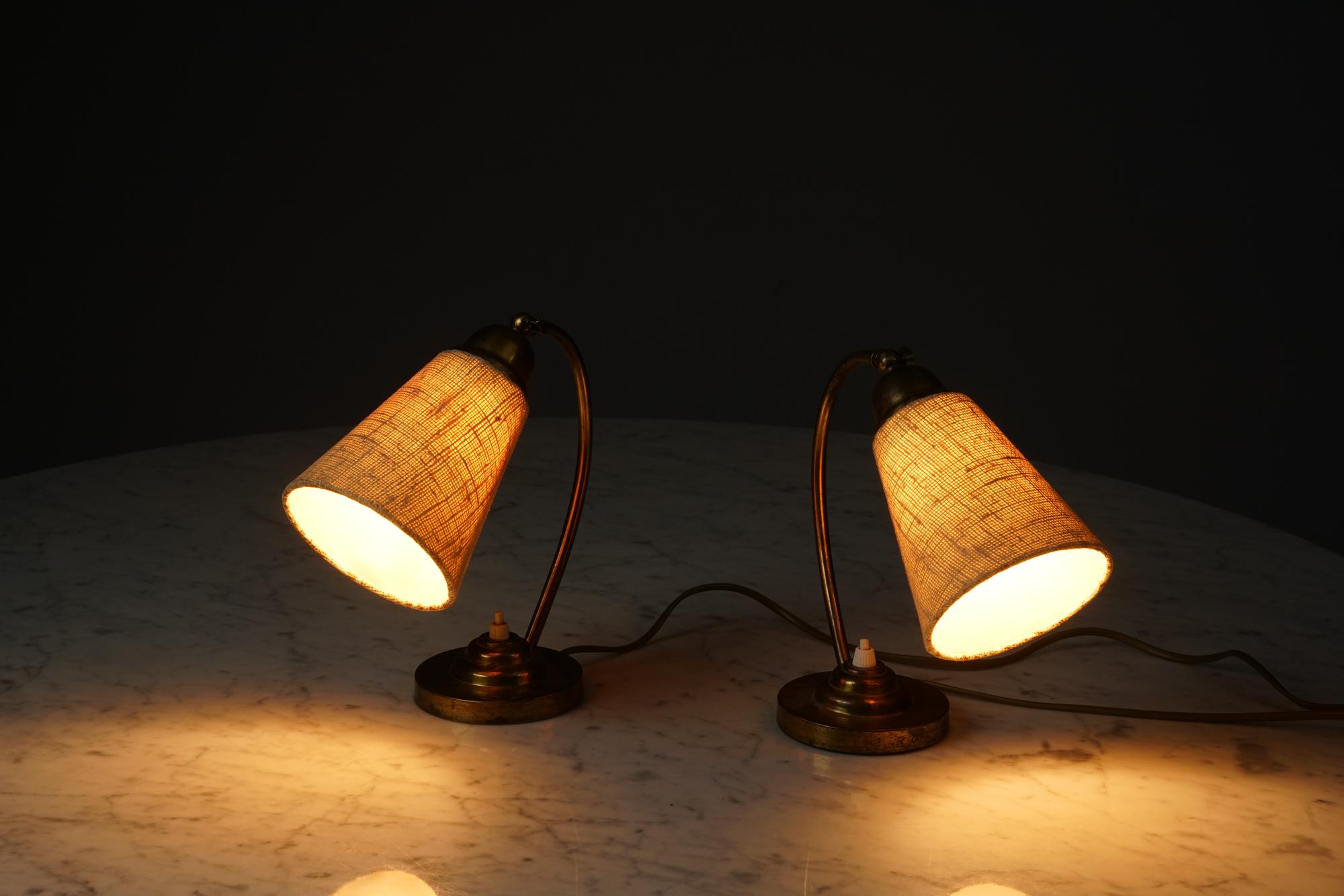 Mid-Century Modern Paavo Tynell style brass table lamps from the 1940s/1950s. Sold as Set of two.

Brass frame and fabric lampshade. Most likely manufactured by Idman Oy or Itsu. 
Beautiful classic Scandinavian modern design. Good vintage condition,