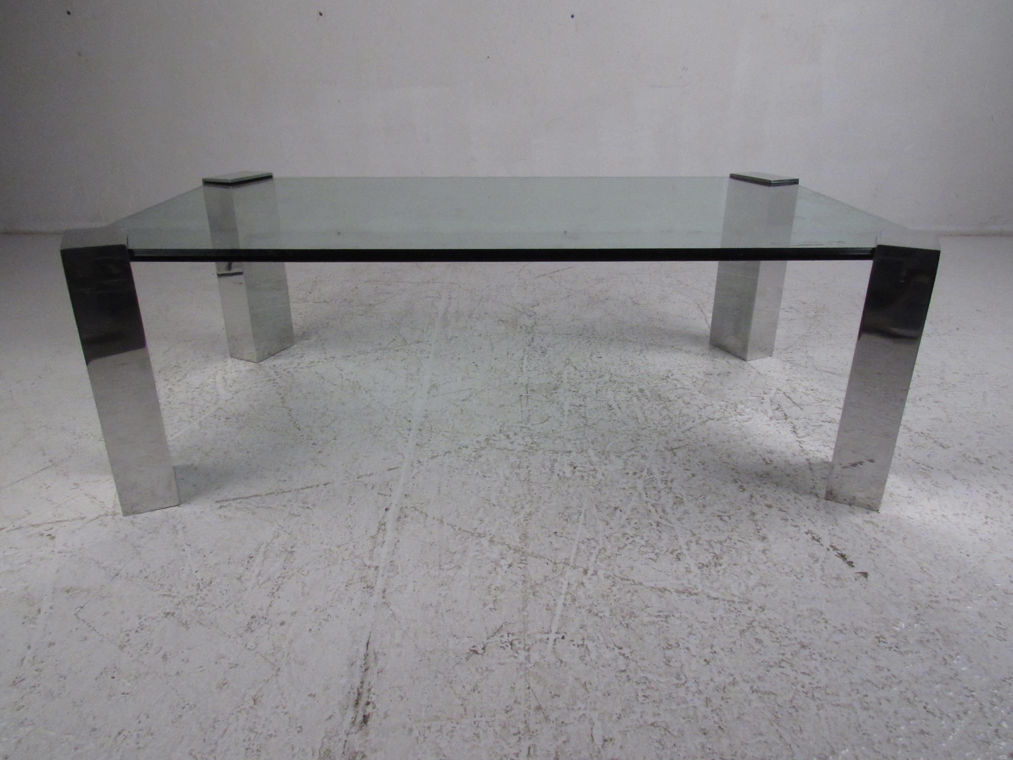 A uniquely designed table that boasts 3/4 inch glass resting comfortably inside of four individual chrome legs. The rectangular chrome legs ensure sturdiness and style in any modern interior. A stunning vintage modern coffee table with thick beveled