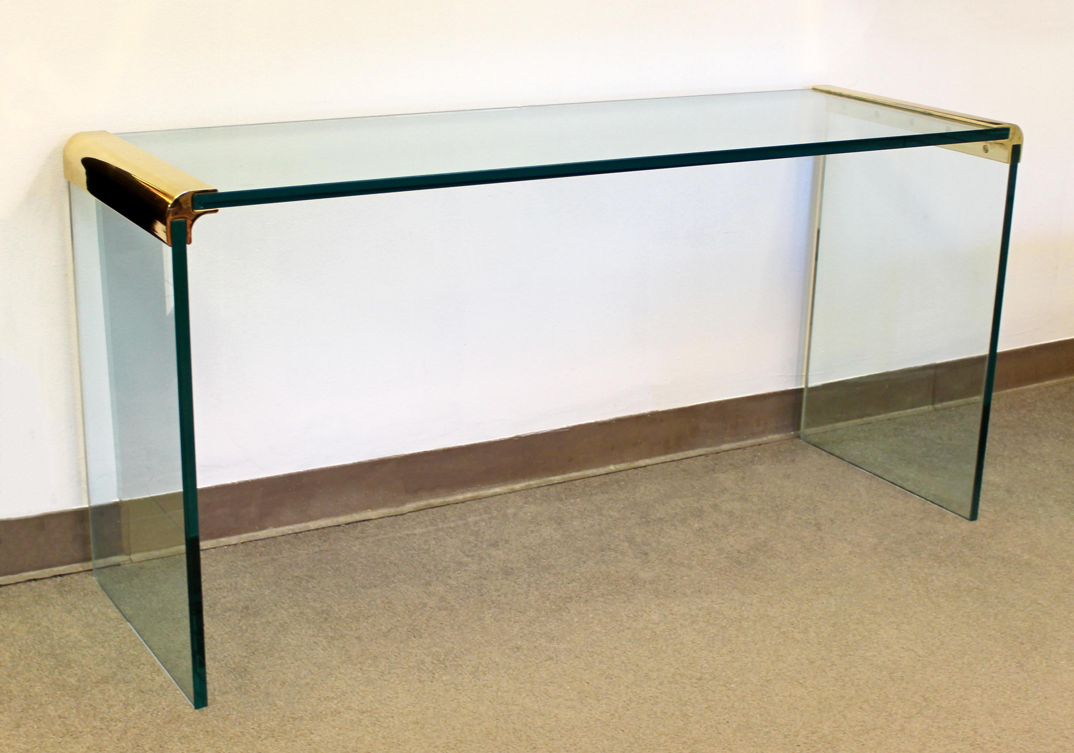 For your consideration is a fantastic, waterfall console table, made of brass and glass, by Pace, circa 1970s. In excellent condition with some minor surface scratches in the glass. The dimensions are 56.5