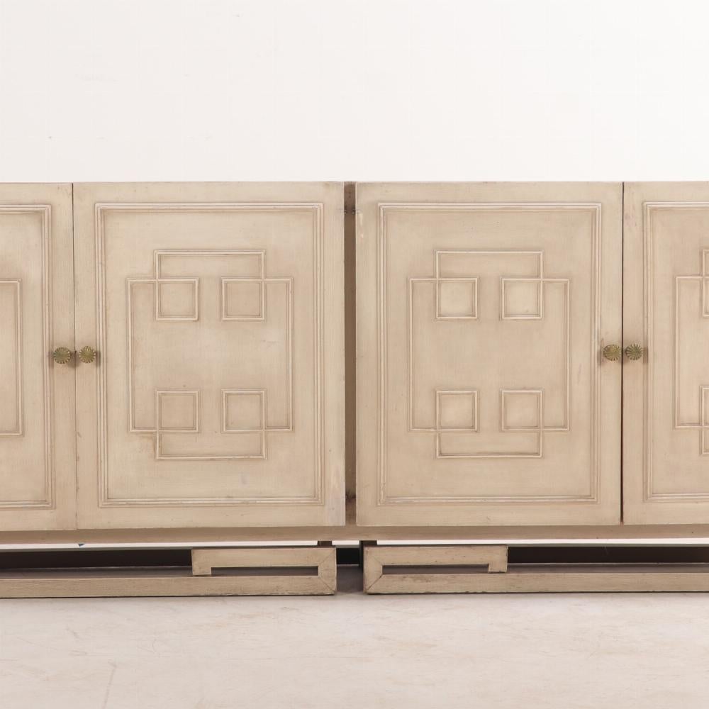 Questa credenza o cassettiera moderna dipinta A.I.C. 1960 aggiungerà una forte impronta architettonica ai tuoi spazi. Dotata di quattro ante che rivelano un interno attrezzato con 12 cassetti e un mobile aperto, la cassa è ornata da applicazioni di