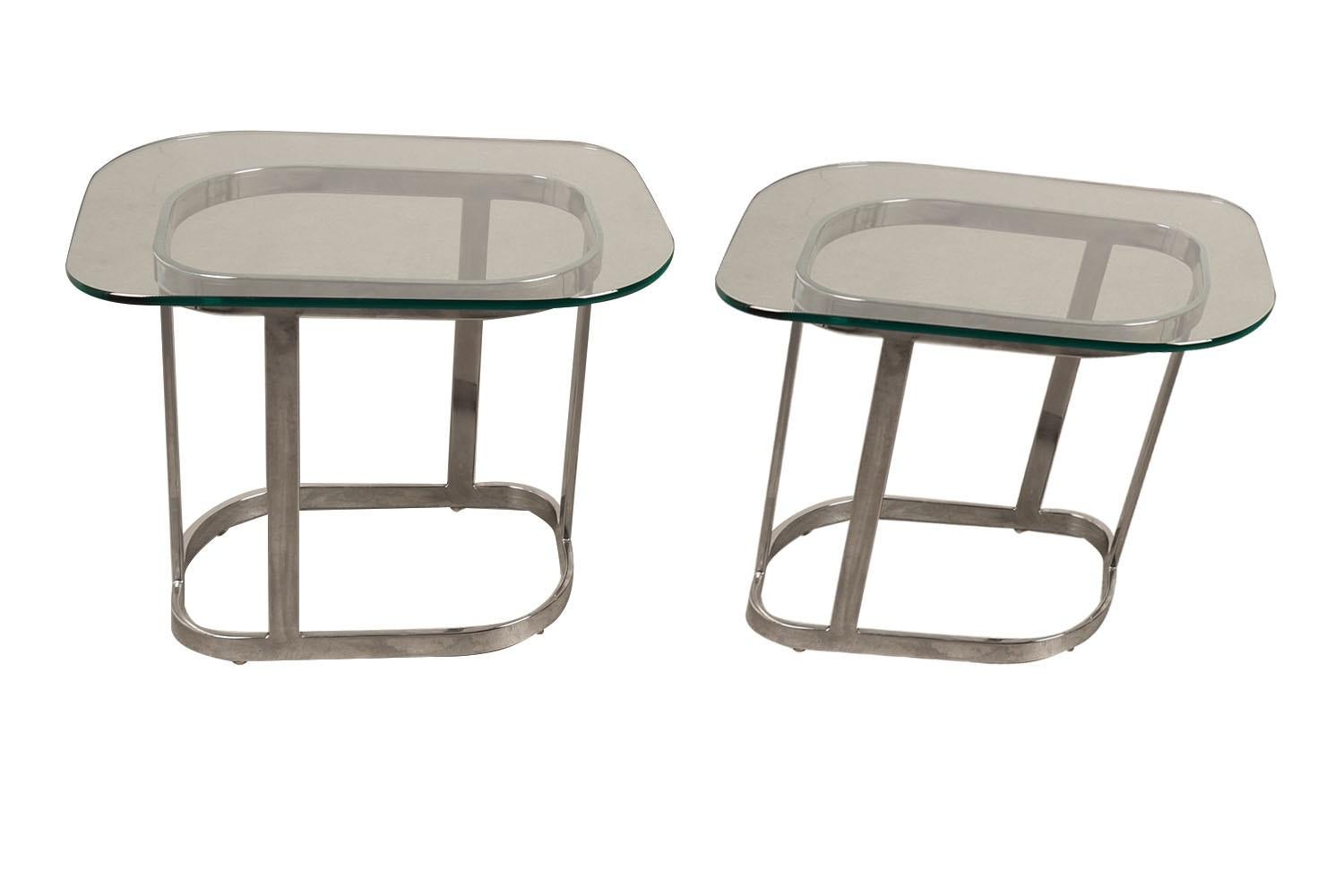 Ein außergewöhnliches Paar Beistelltische aus Glas aus der Mitte des Jahrhunderts mit modernistischem Design, elegant und üppig. Jedes Element besteht aus 3/8″ dickem Glas, das auf einem verchromten Sockel mit 1/2″ dicken Chromleisten ruht, wodurch
