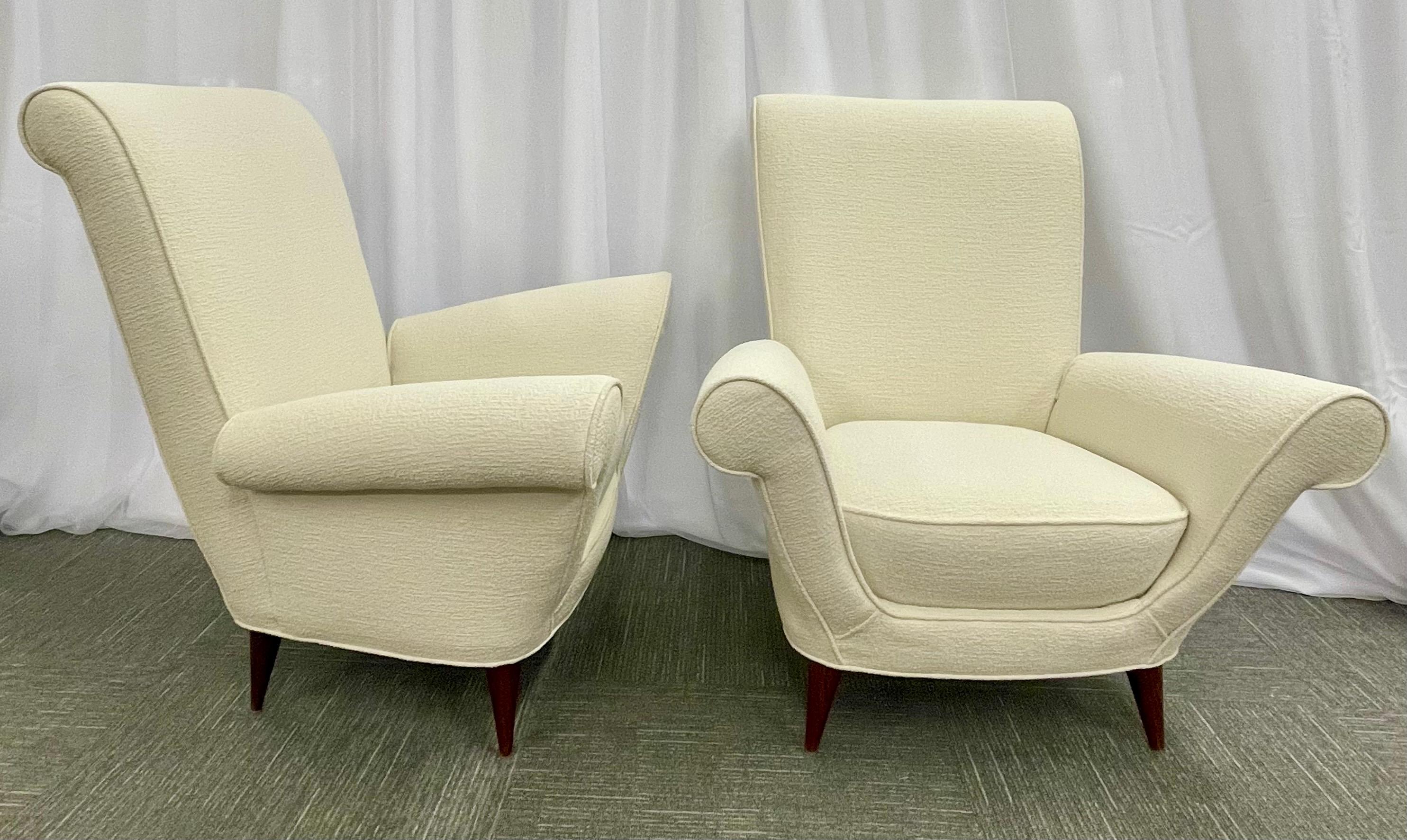 Pair of arm chairs in Italian in the style of Paolo Buffa newly reupholstered in a luxurious ivory Kavet Bouclé.
These sleek and stylish arm, lounge or wingback chairs are strong and sturdy. Each having the classic angled legs supporting a large U