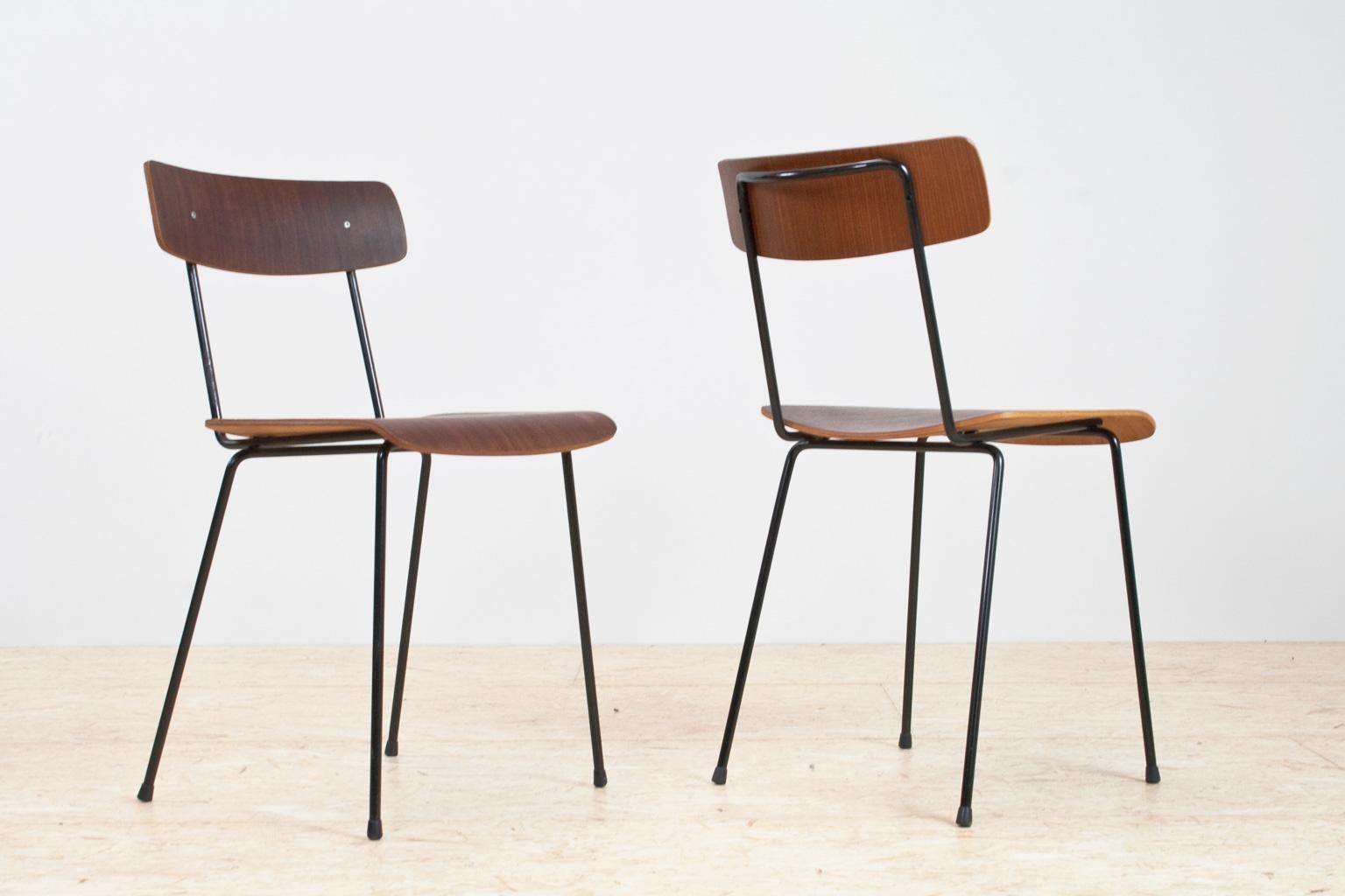 Minimalist and Mid-Century Modern pair of A.Cordemeyer chairs in brown plywood and black metal. Designed in 1959 for Dutch Industrial manufacture Gispen. These elegant and Minimalist dining room pieces with 'high socks' floor caps are rare to find.