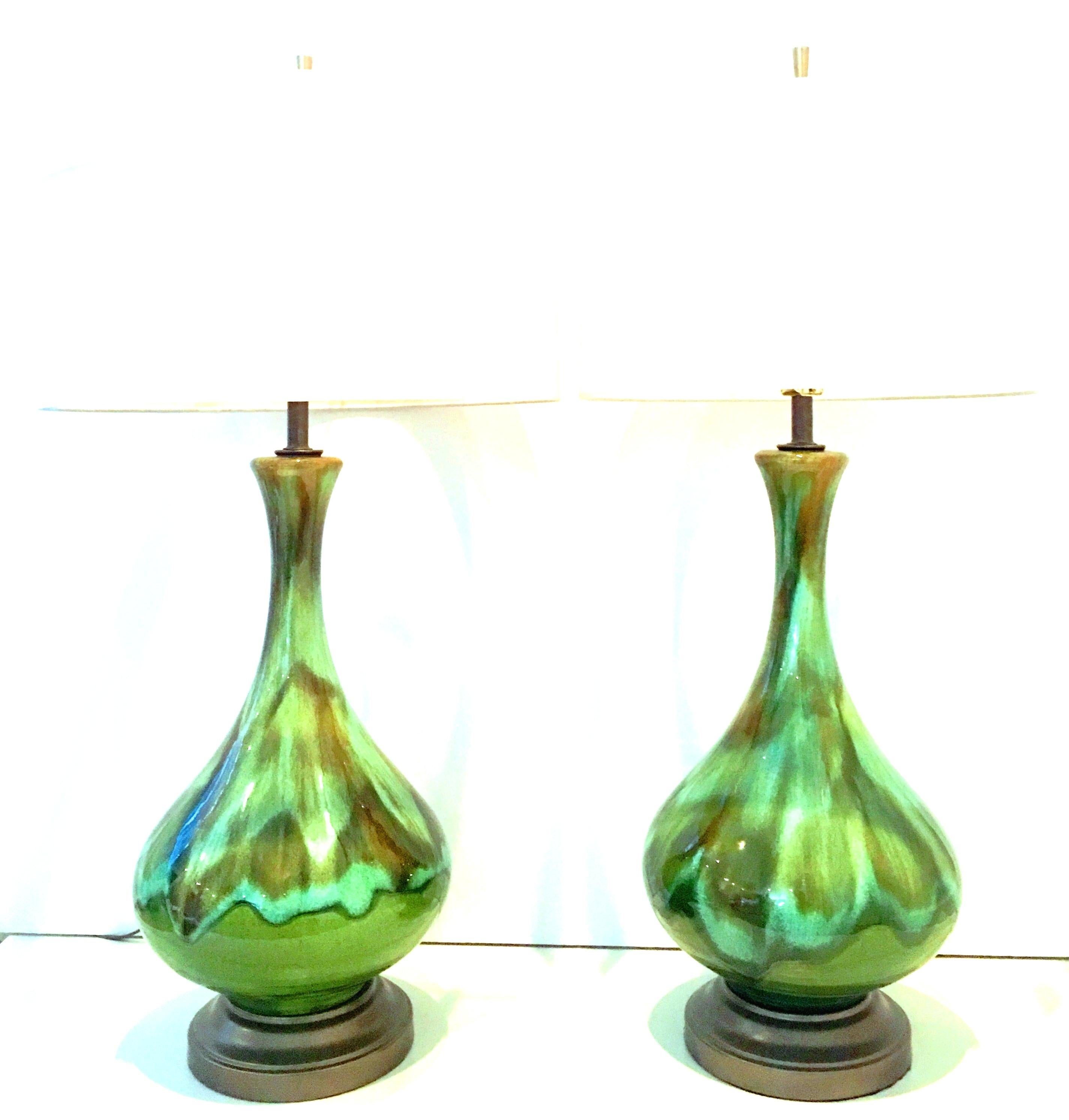 Mid-Century Modern pair of American ceramic drip glaze and brass table lamps. This pair of ceramic lamps features an avocado green ground with turquoise, brown and shades of green. Original brass fittings, newly wired with brown cords. Includes a