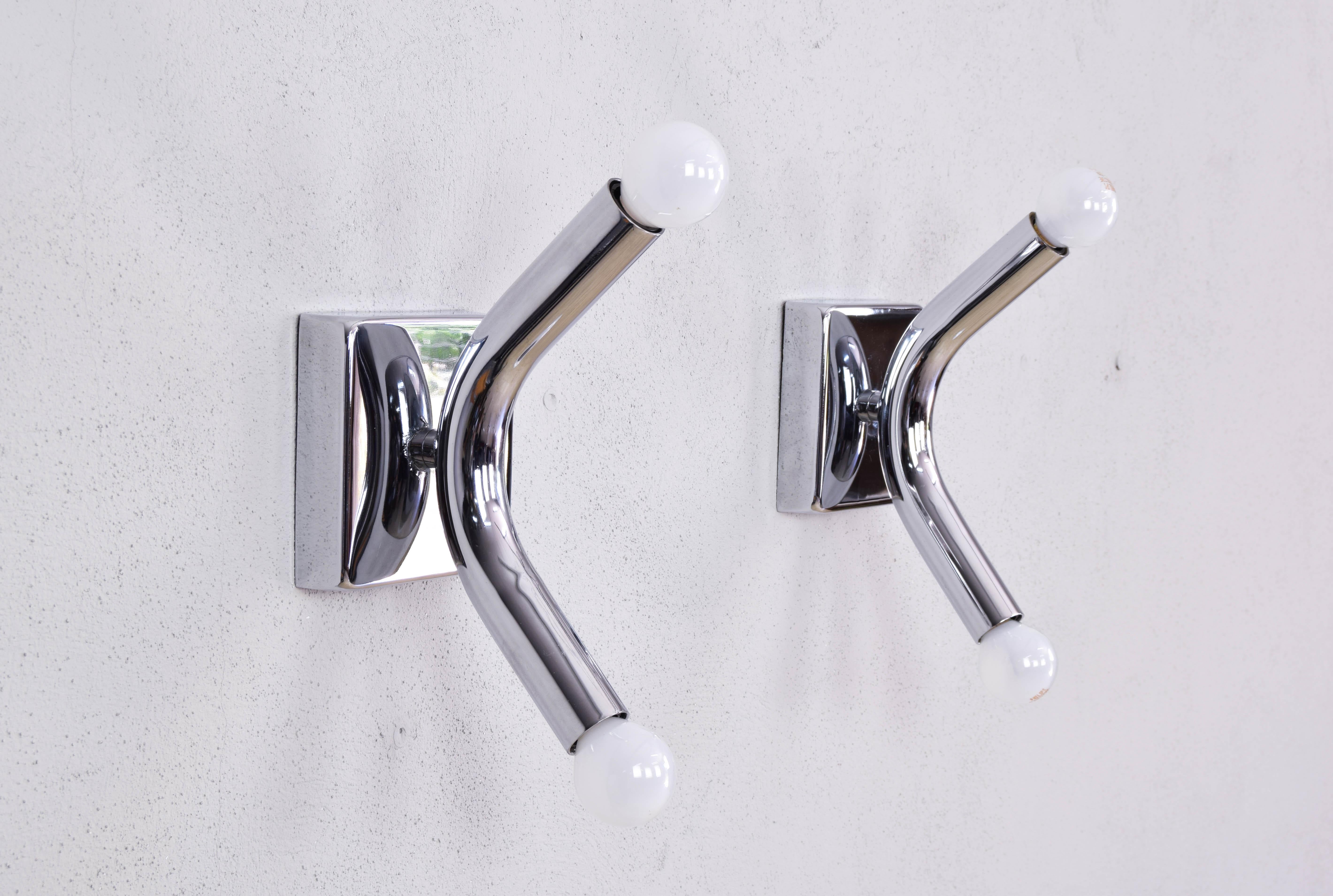 Pair of Angelo Brotto style chrome tubular steel wall lights, made in Italy in the 1960s. Composed of a chrome steel plate that has a tubular arm with a light point at each end. With a sophisticated appearance and in a very good state of