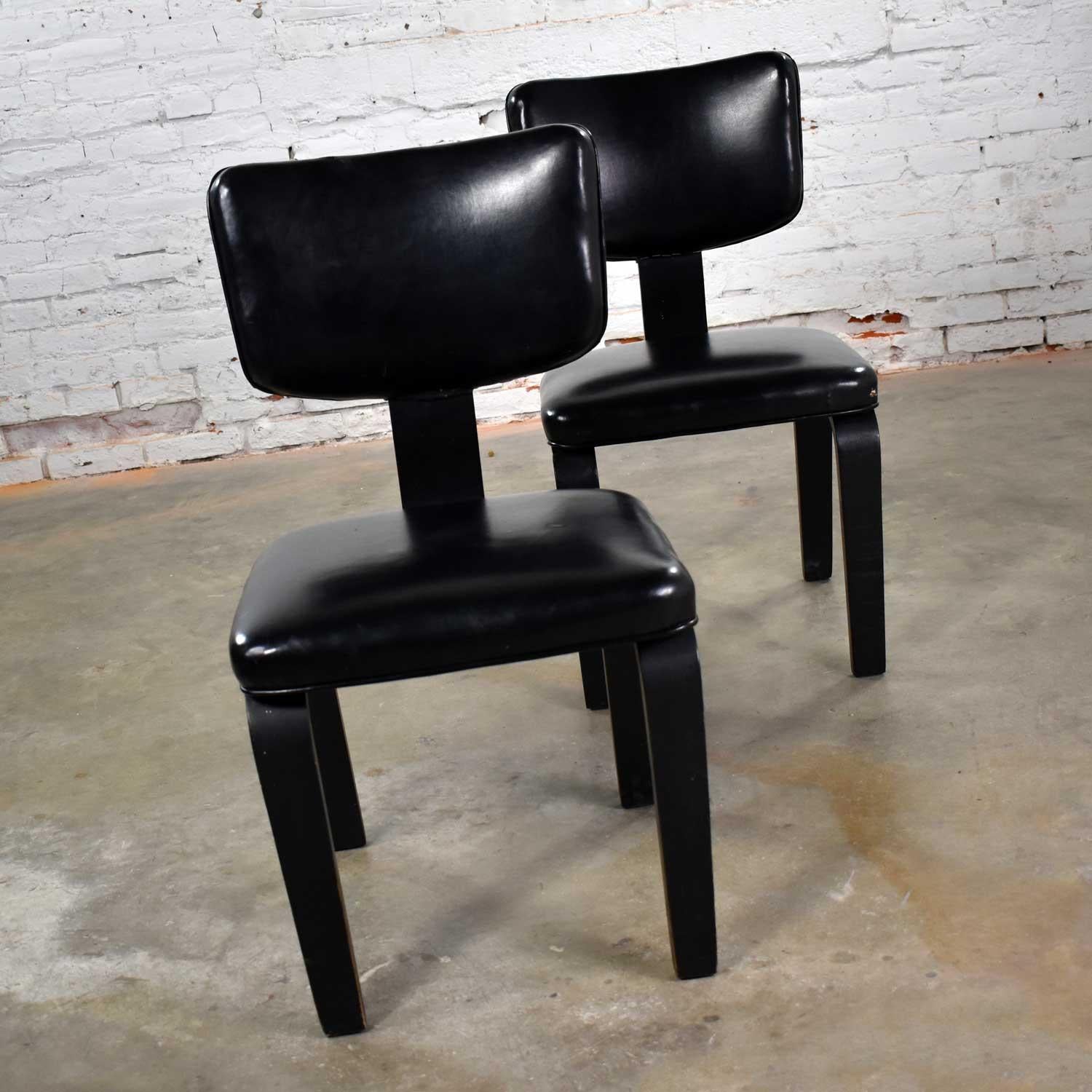 Handsome pair of Thonet bentwood Mid-Century Modern chairs in black with black vinyl upholstery. They are in good vintage condition. The vinyl does have a few cuts and nicks. The black painted wood shows age appropriate wear and patina. The