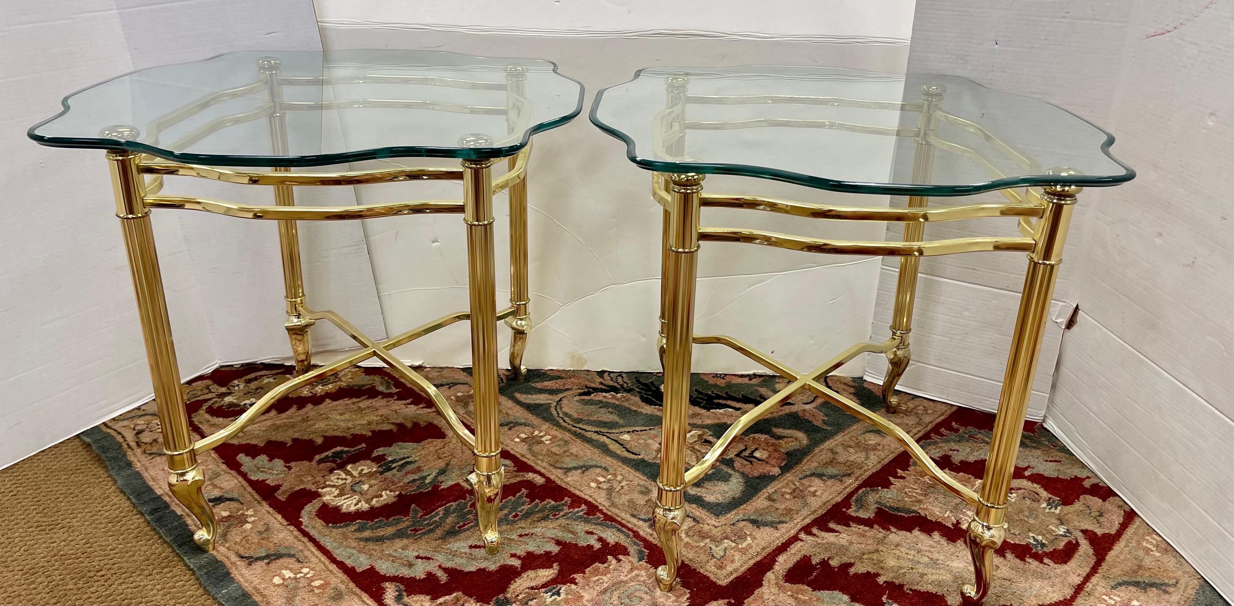 Elegant pair of matching Maison Jansen style brass and glass side table.
Glass features scalloped edges and bevel throughout. Brass is in great condition 
and these set has great scale and better lines.